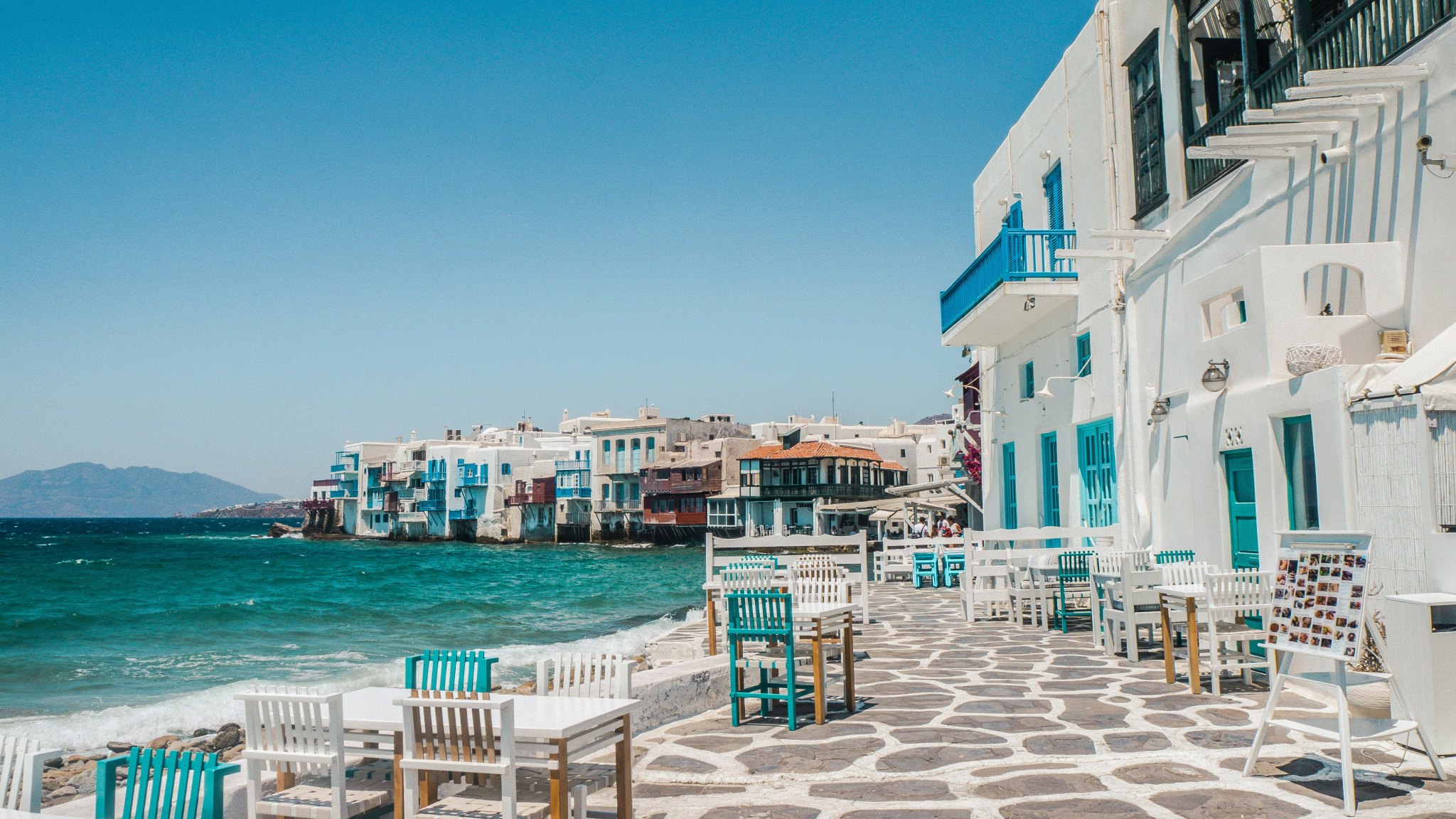 Little Venice in Mykonos featuring white buildings with blue accents overlooking turquoise Aegean waters - perfect starting point for luxury Greek Cyclades island hopping adventures