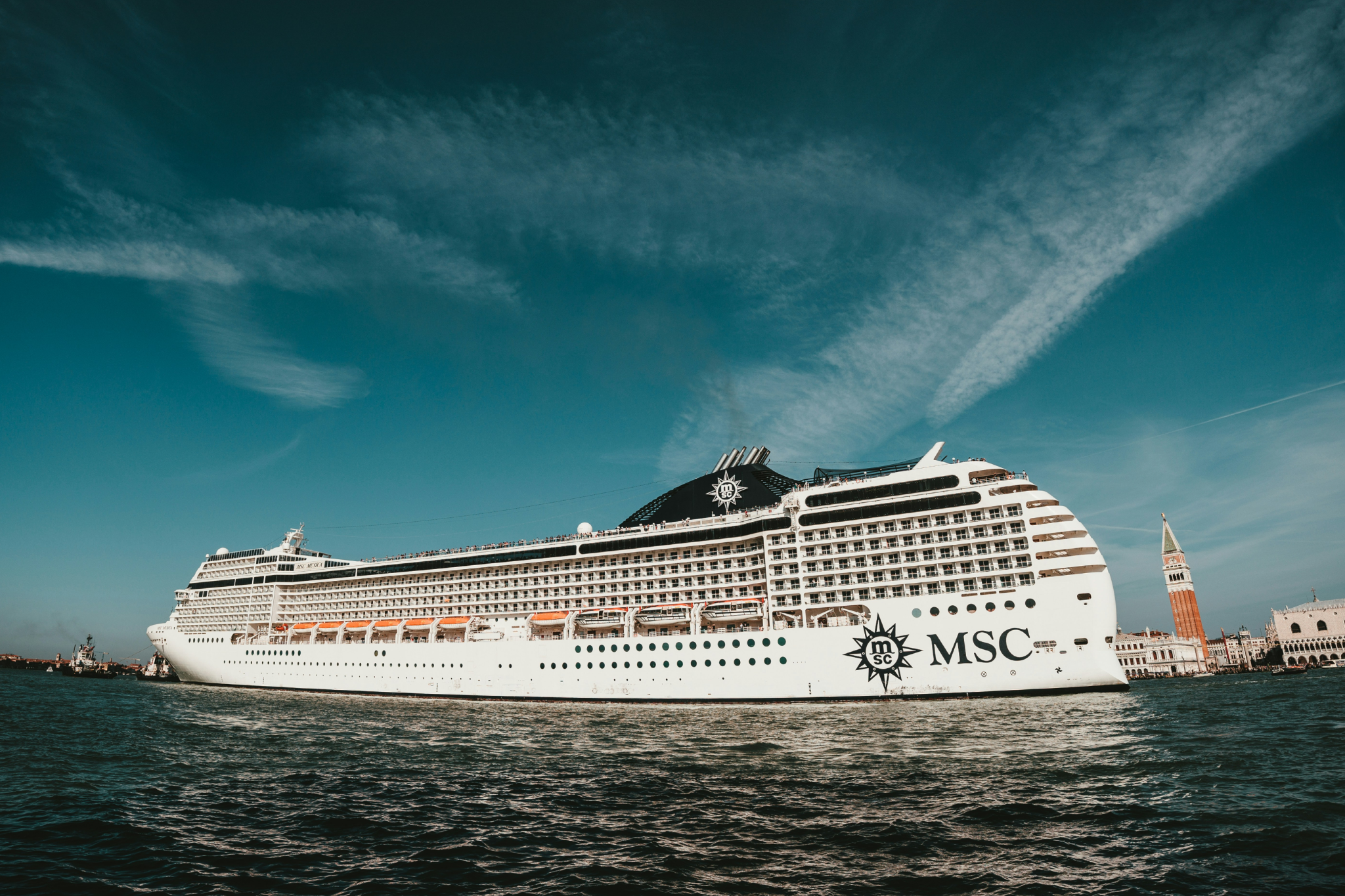 An MSC cruise ship sailing past Venice’s iconic canals and landmarks, reflecting modern ship design and amenities, highlighting the innovation shaping 2025 Cruise Trends.