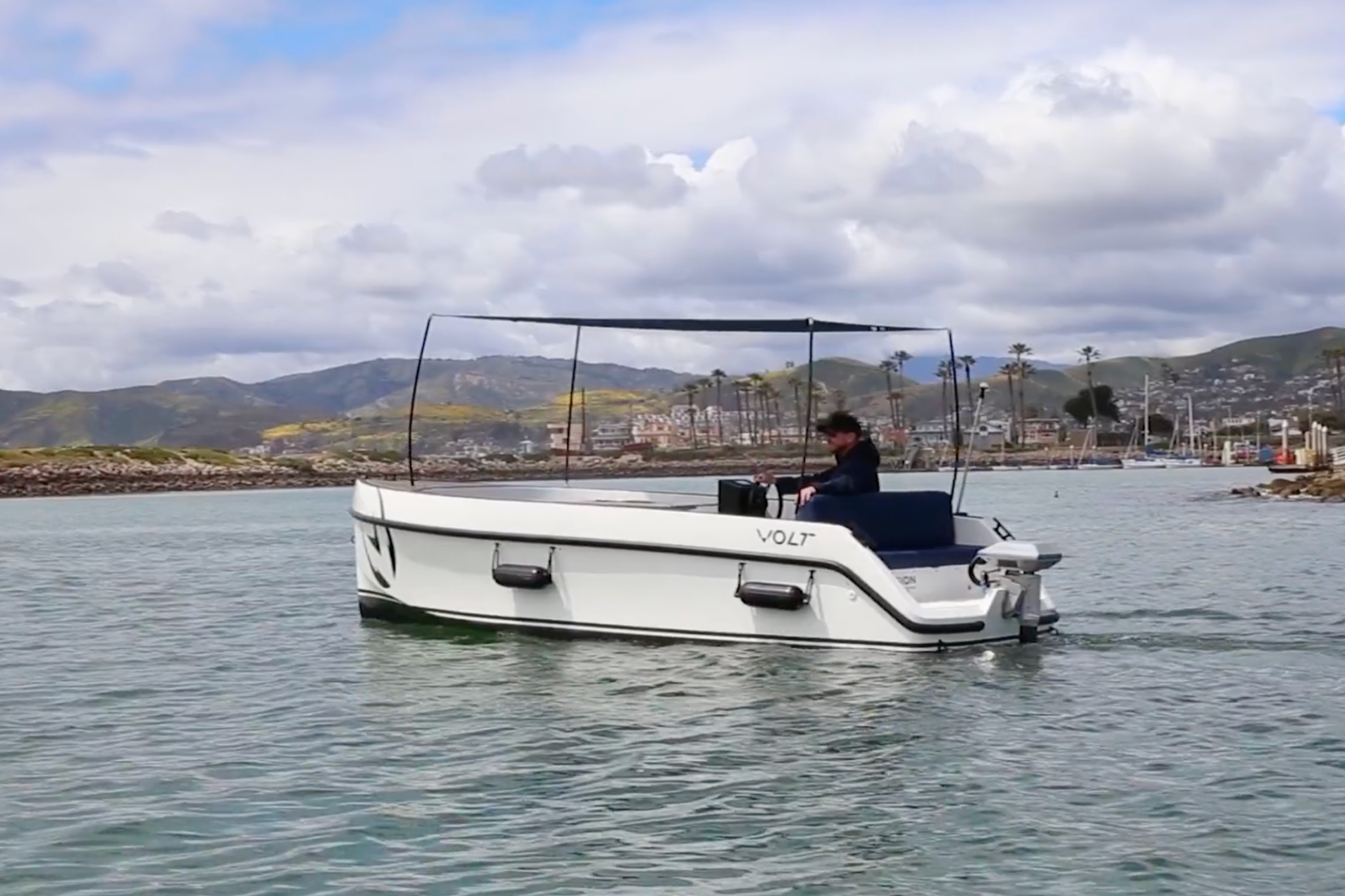 The 2025 Volt 180 cruising at a steady pace on calm water, illustrating its smooth, low-speed performance and range designed for quiet electric cruising.