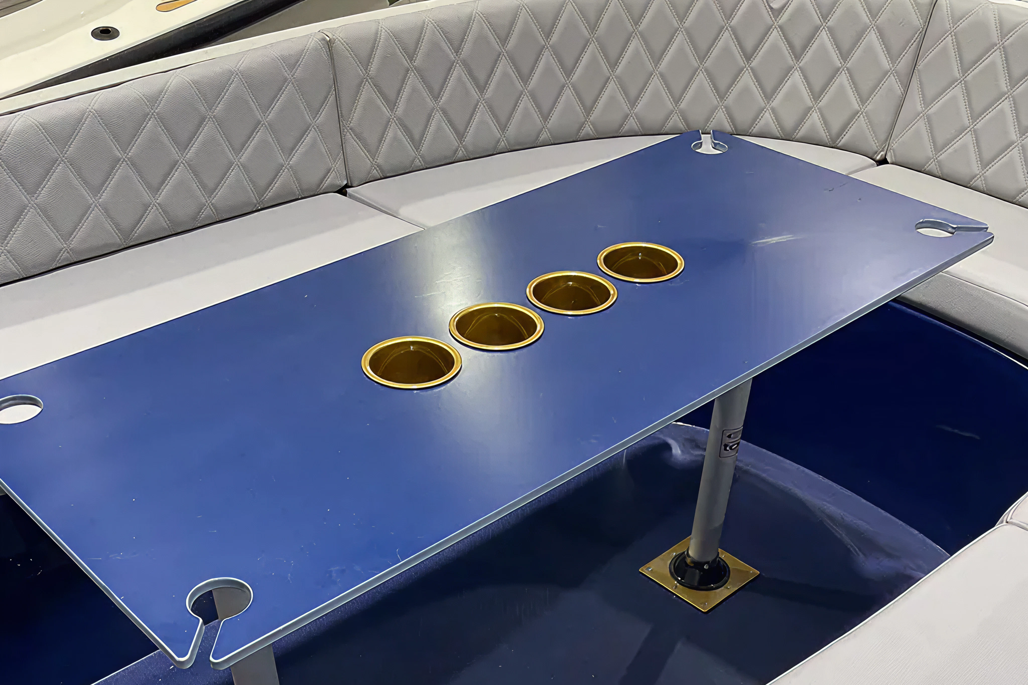 Interior seating and Corian table setup on the 2025 Volt 180, highlighting the open layout, built-in cup holders, and social-focused onboard experience.