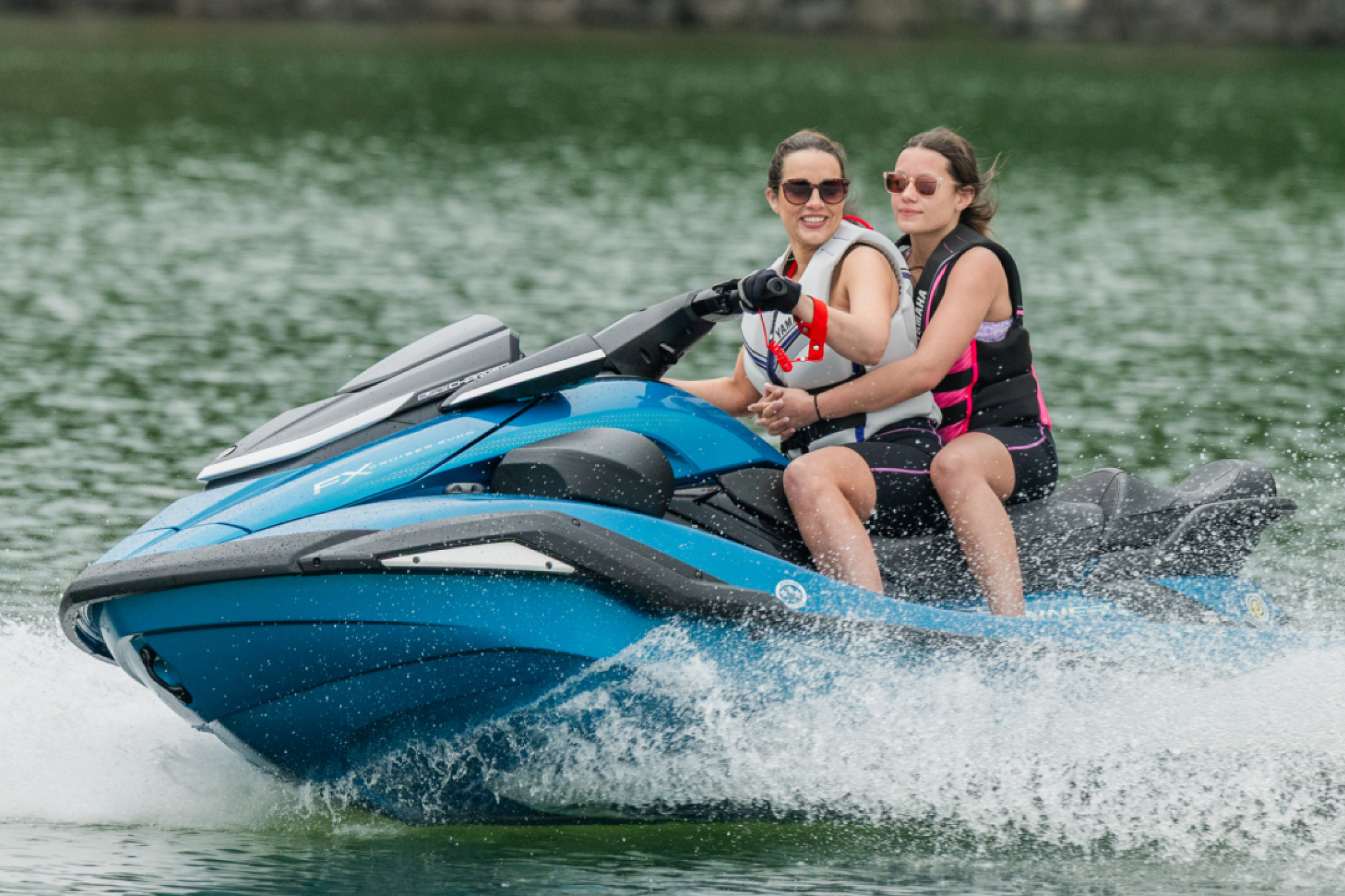 Two riders cruising on the 2026 FX Cruiser SVHO, showcasing its stable hull, passenger-friendly seating, and smooth performance on open water.