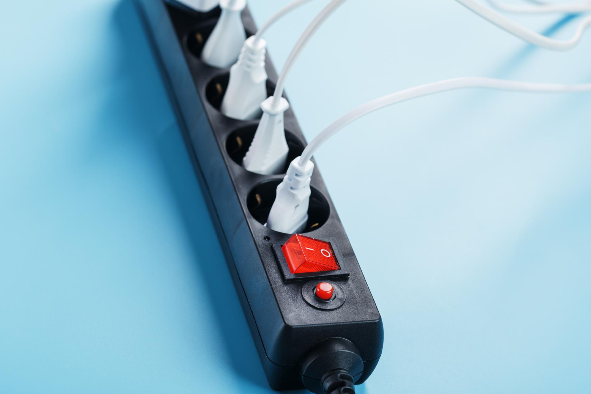 A surge protector with multiple devices plugged in, illustrating one of the things you should never do in your cruise cabin due to electrical and fire risks.
