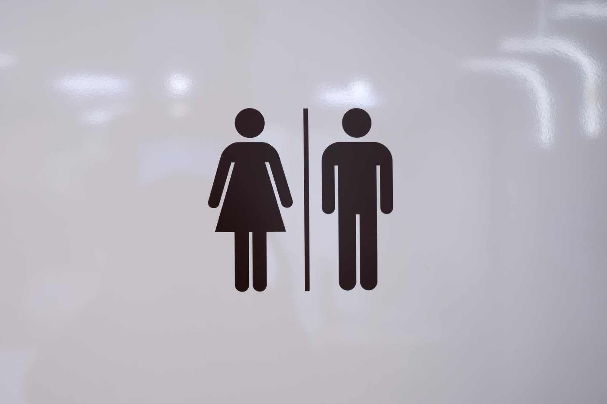 A restroom sign and plumbing context representing things you should never do in your cruise cabin, including flushing non-toilet paper items that can damage ship systems.