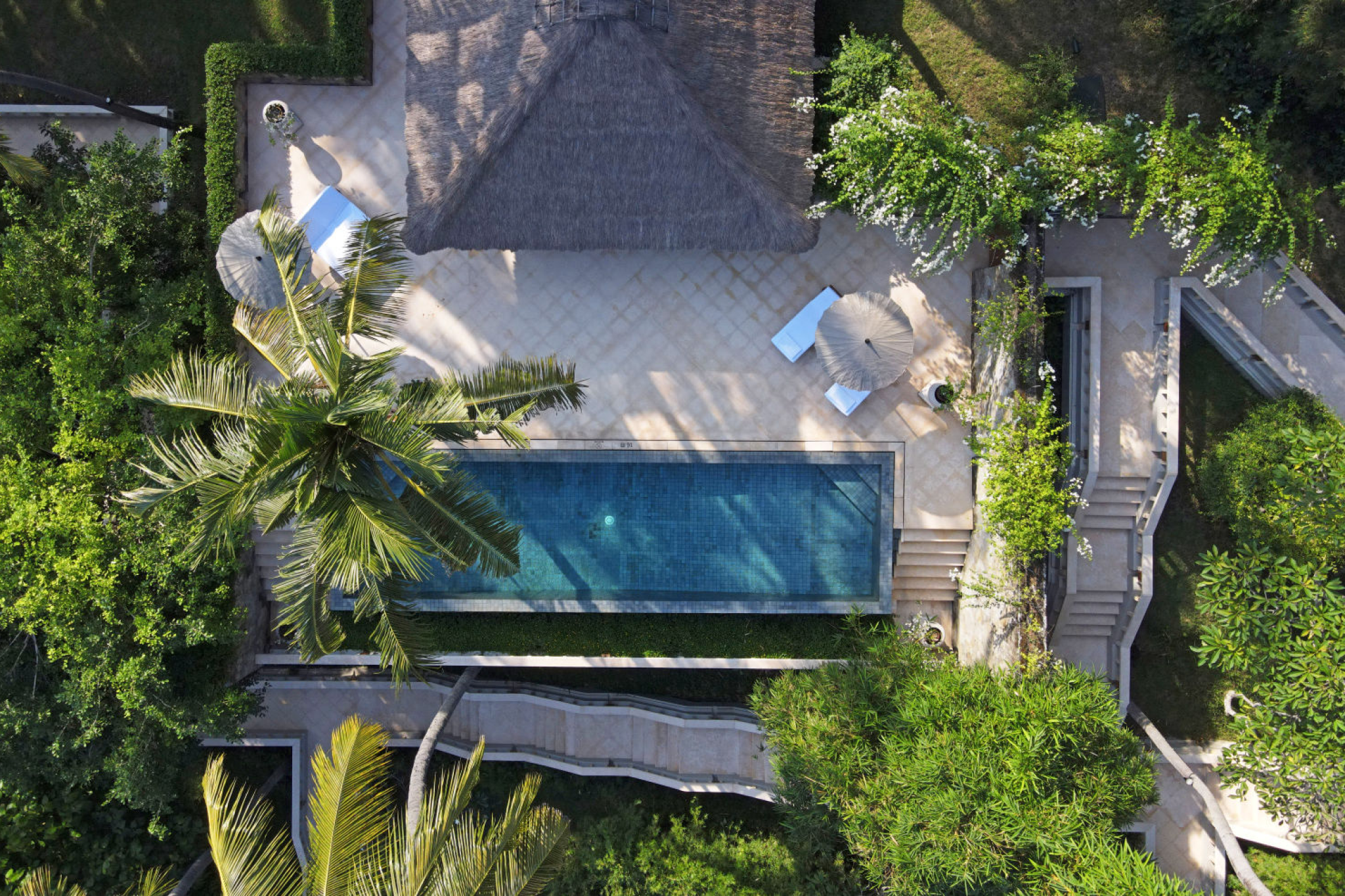 Top-down view of Amankila’s private pool villa surrounded by tropical gardens and palm trees