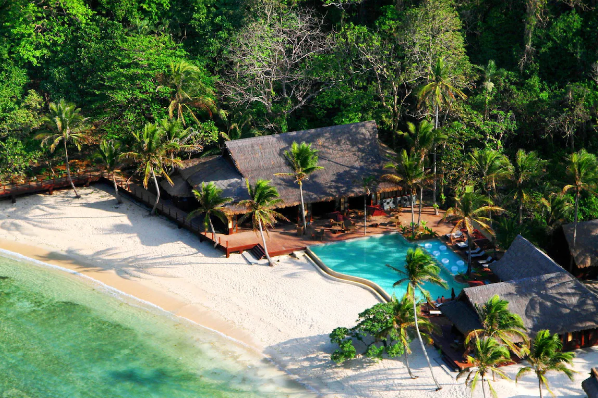 Cauayan Island Resort in El Nido Palawan viewed from above, with beachfront villas, an infinity pool, and surrounding tropical forest — a top choice among the best beach resorts in El Nido Palawan.