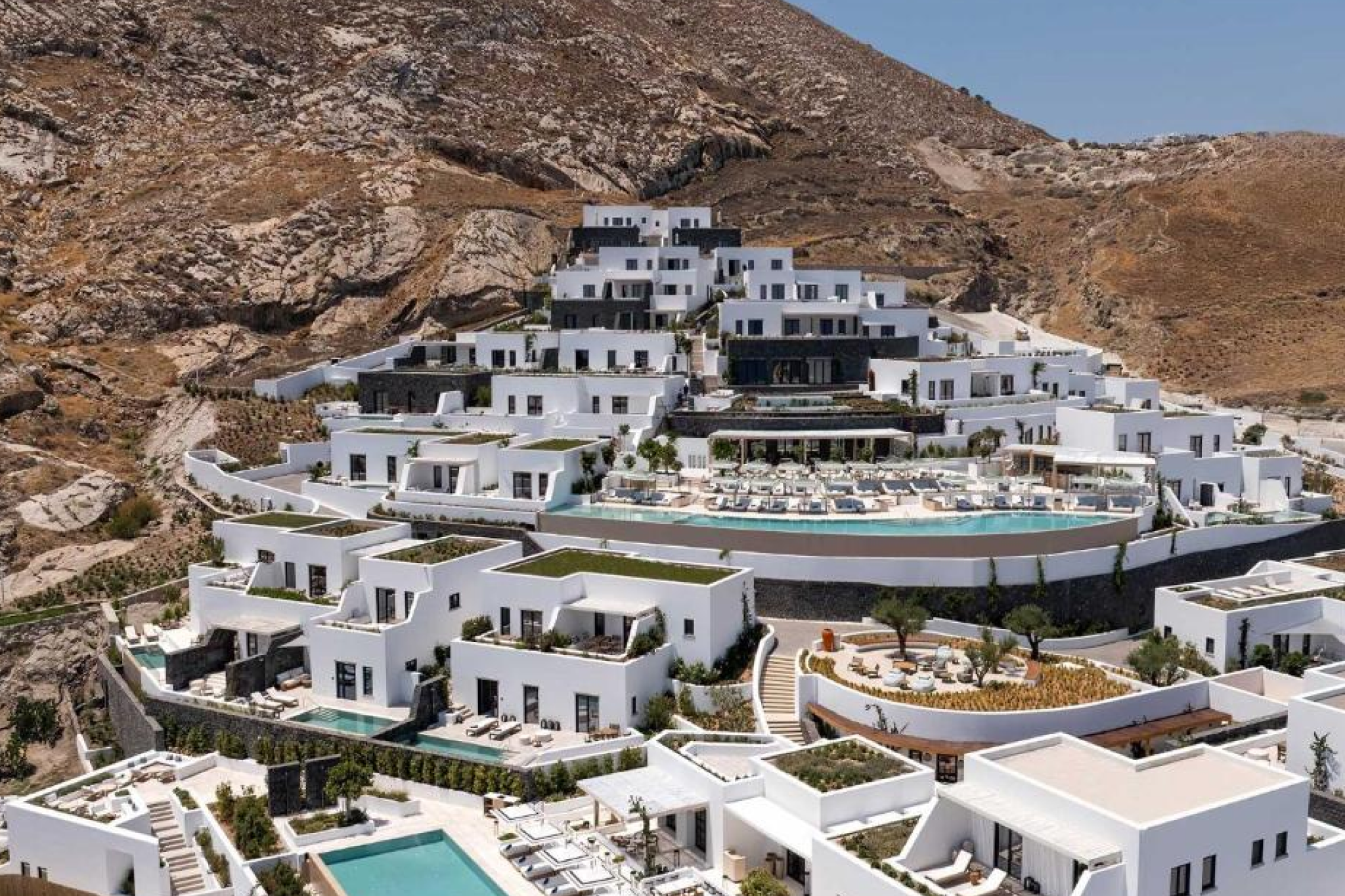 Infinity pool at Sandblu Resort Santorini, one of the Best Beach Resorts in Santorini, featuring white minimalist design and panoramic views of Kamari Beach.