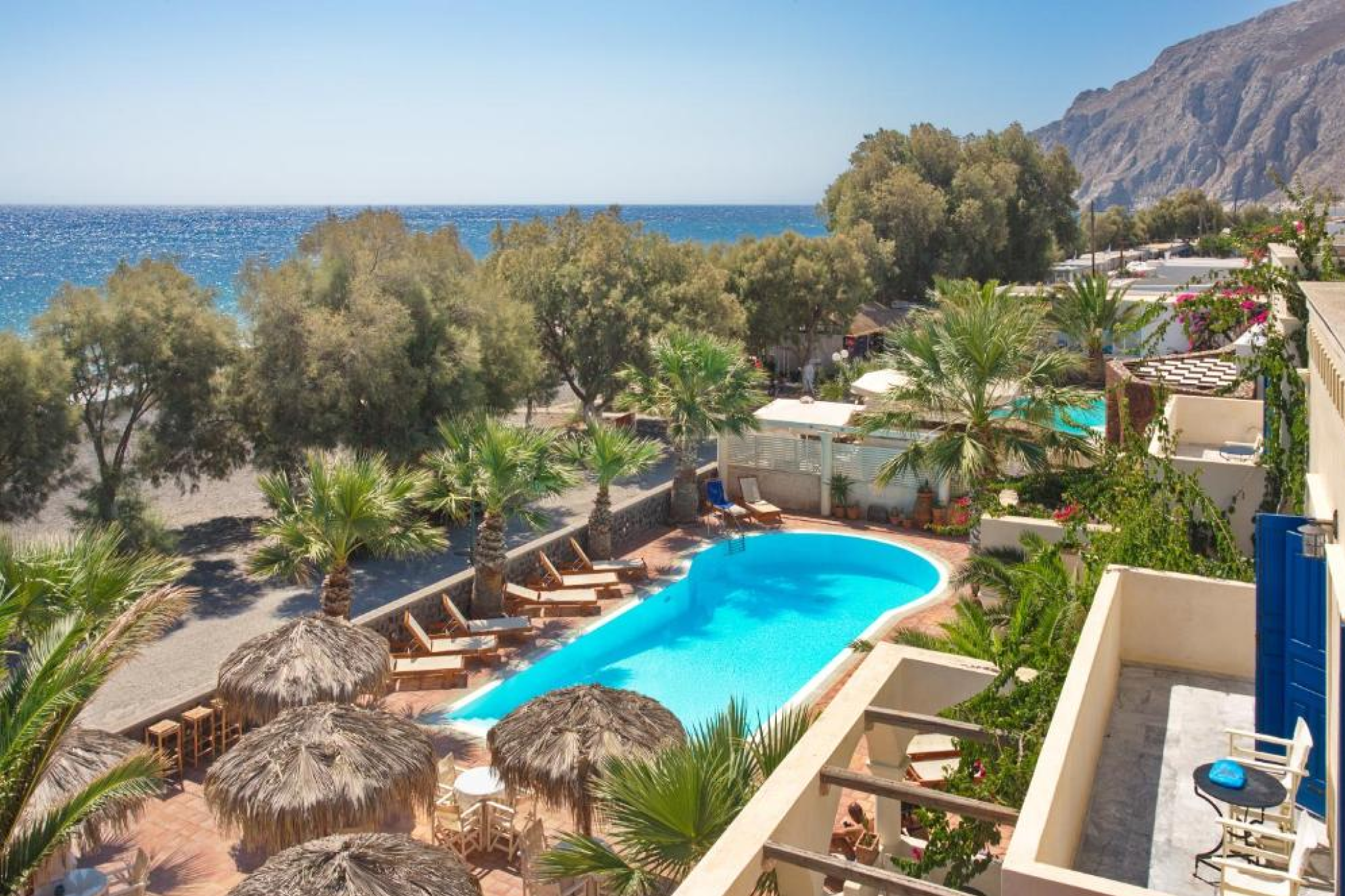 Seaside pool and terrace at The Boathouse Hotel, one of the Best Beach Resorts in Santorini, offering a relaxed family-run atmosphere along Kamari Beach.