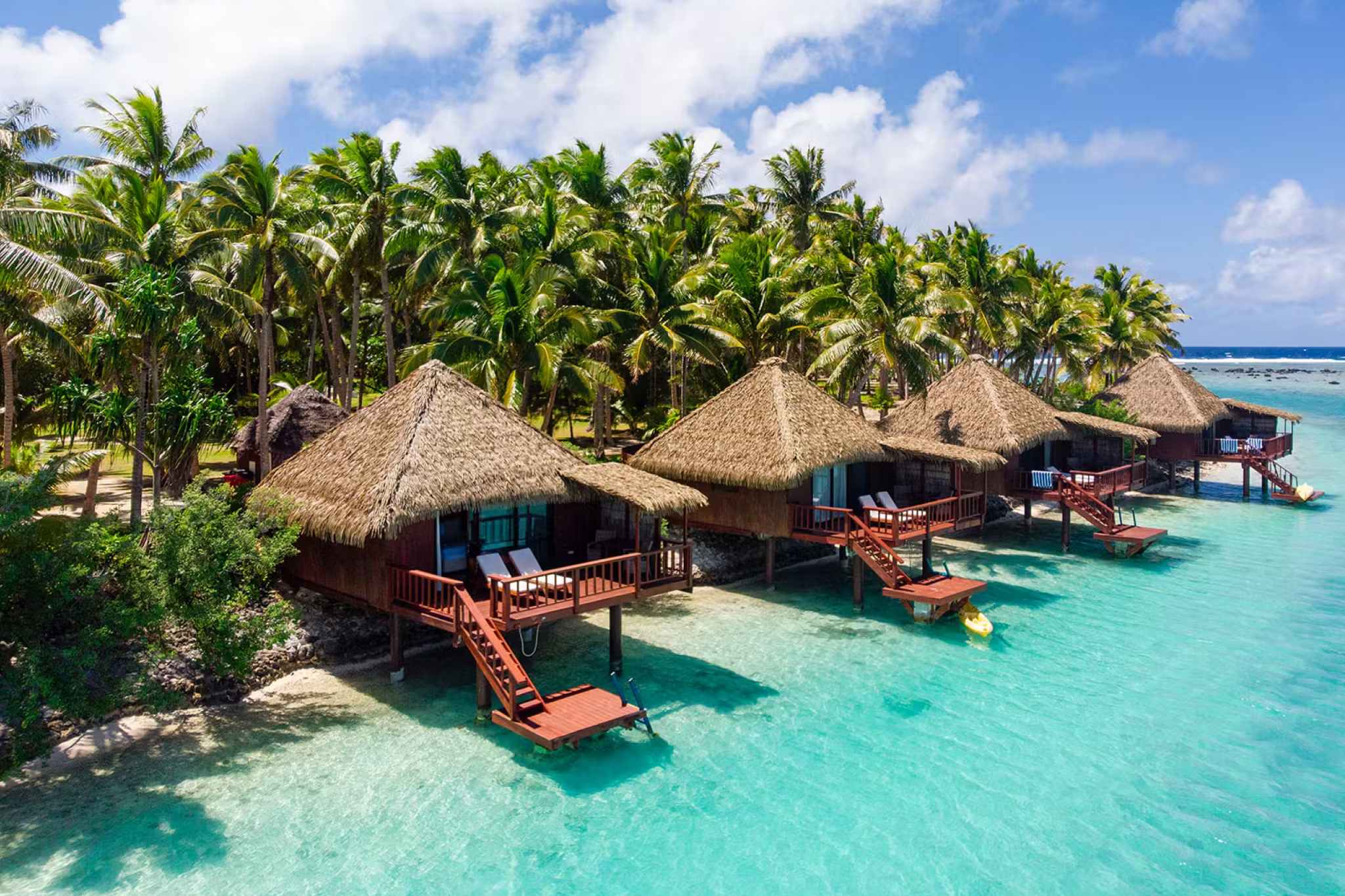 Overwater bungalows on crystal-clear turquoise waters at Aitutaki Lagoon Private Island Resort, the only overwater accommodation in the Cook Islands and top of the best Aitutaki resorts list.
