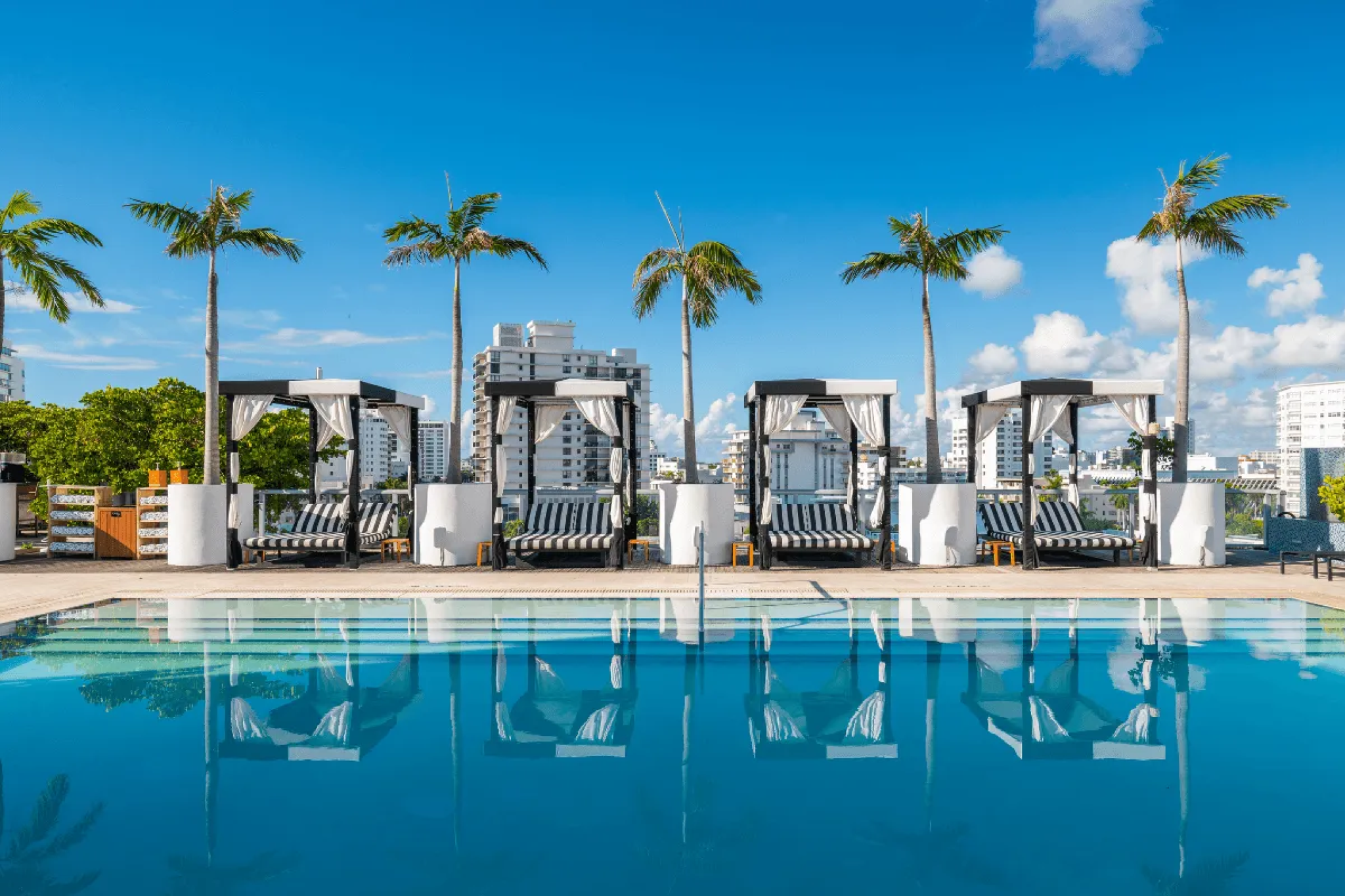 Rooftop pool with cabanas and palm trees at 1 Hotel South Beach — showcasing modern coastal design among the best luxury beach resorts in the United States.