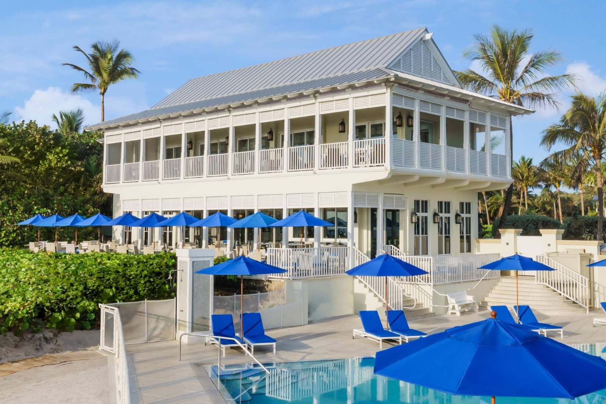 Poolside view with blue umbrellas at The Seagate Hotel & Beach Club in Delray Beach — one of the best luxury beach resorts in the United States.