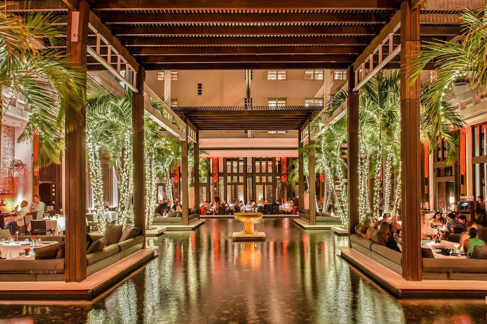 Elegant dining area surrounded by palm trees and water features at The Setai Miami Beach — among the best luxury beach resorts in the United States.