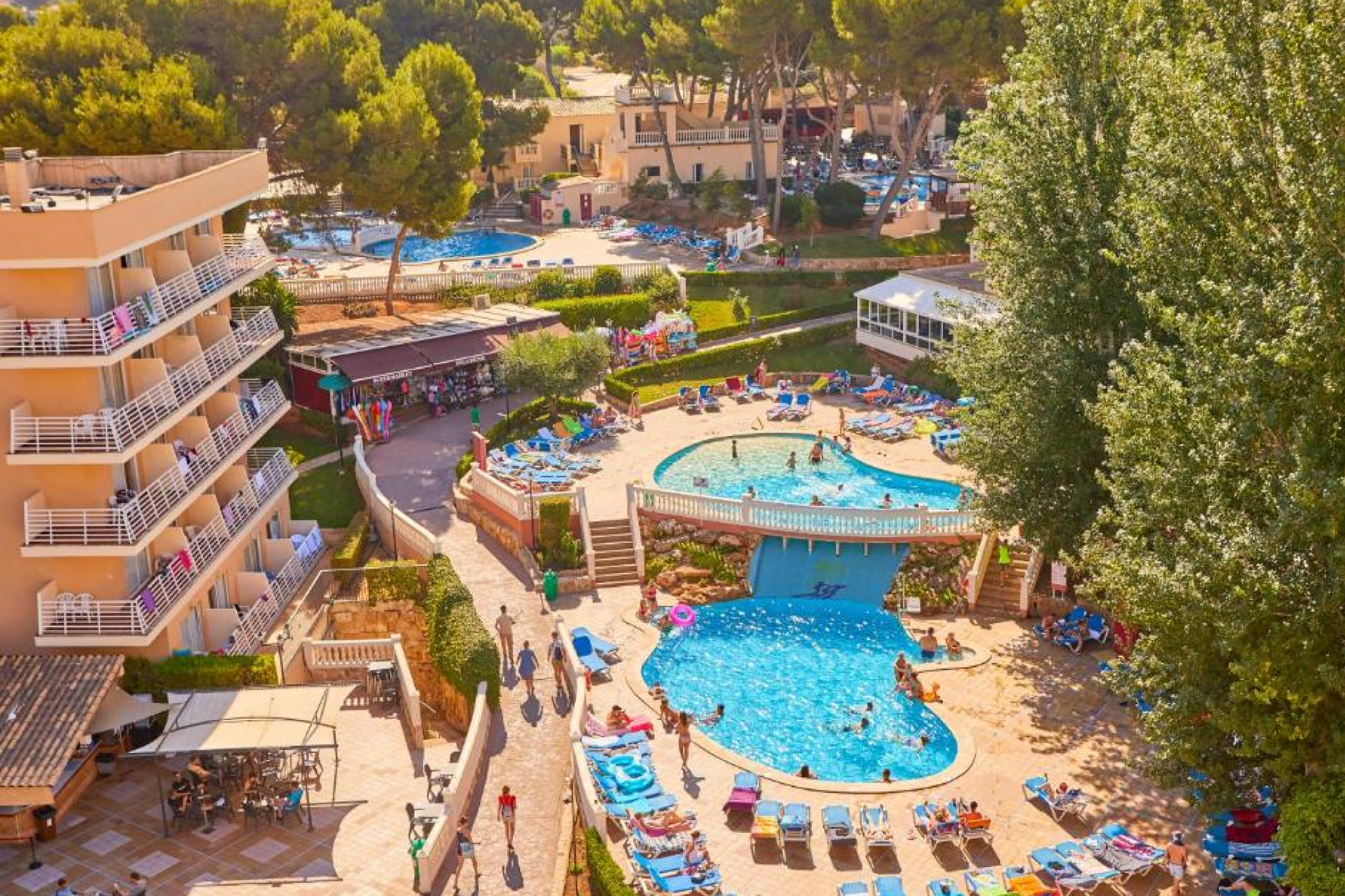 Elevated view of Meliá Calviá Beach resort beside Calvià’s coastline with clear waters, elegant pool deck, and lush greenery — one of the best beach resorts in Mallorca for couples and families.