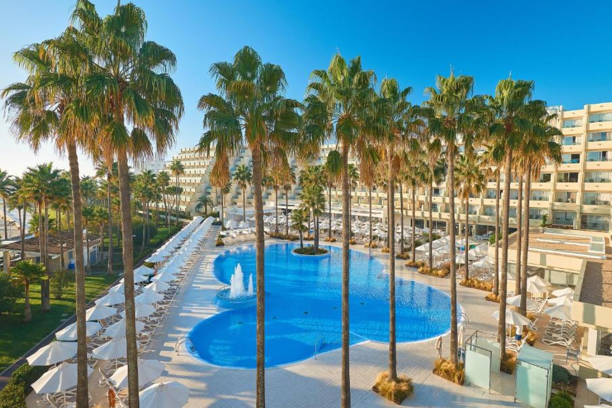 Panoramic view of PortBlue Club Pollentia Resort & Spa between the bay and nature reserve, with expansive pools and Mediterranean architecture — ranked #1 among the best beach resorts in Mallorca for active, nature-connected luxury.