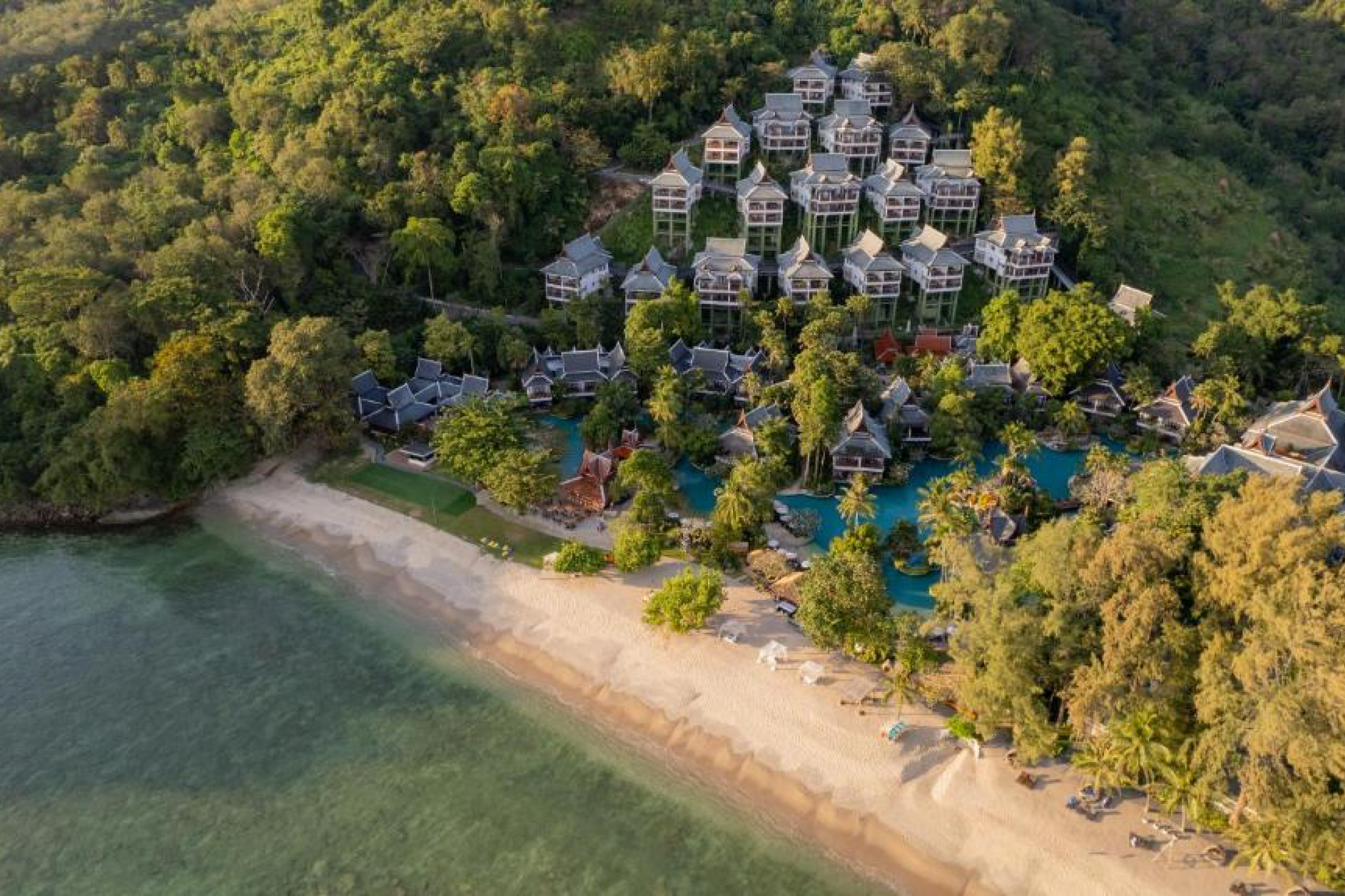 Aerial view of Thavorn Beach Village Resort & Spa with hillside villas, tropical gardens, and private beachfront — one of the best beach resorts in Phuket.