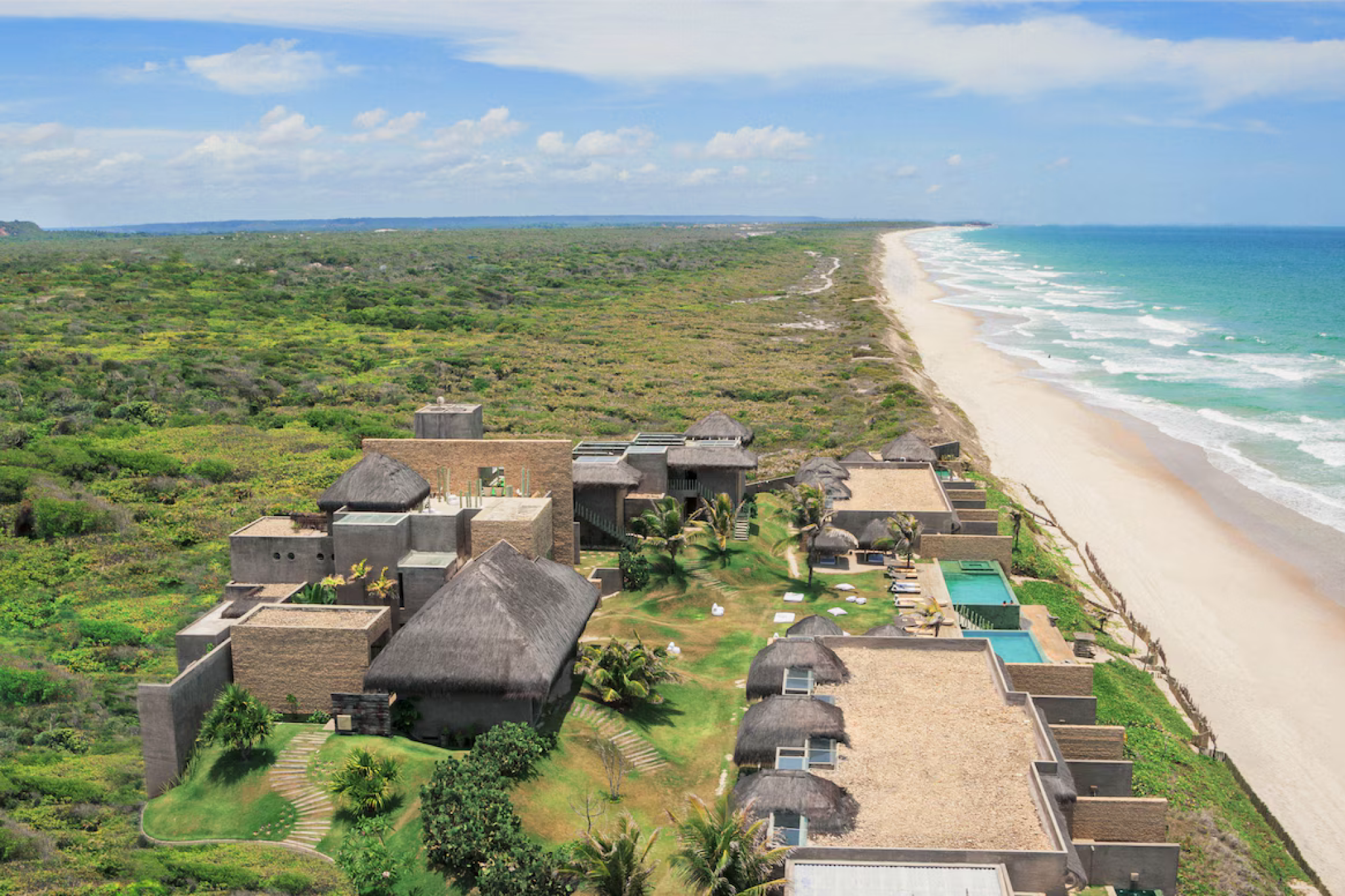 A striking aerial shot of Kenoa Resort along Brazil’s Alagoas coastline, featuring eco-modern villas, natural thatched roofs, and miles of untouched golden beach backed by lush greenery — capturing the intimate, design-forward appeal that ranks it among the best beach resorts in South America in 2025.