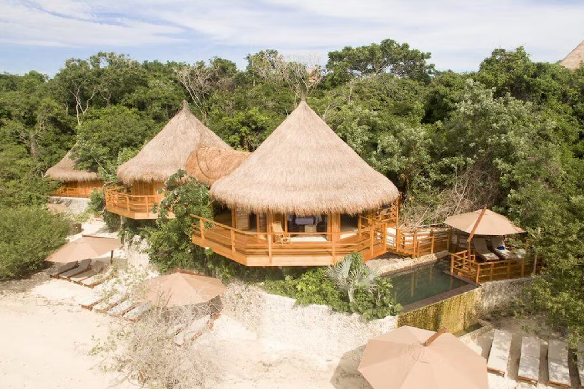 An elevated view of Las Islas resort with its thatched-roof treetop and beachfront bungalows nestled among dense mangroves and overlooking calm turquoise waters — a nature-immersive escape highlighted as one of the best beach resorts in South America in 2025.
