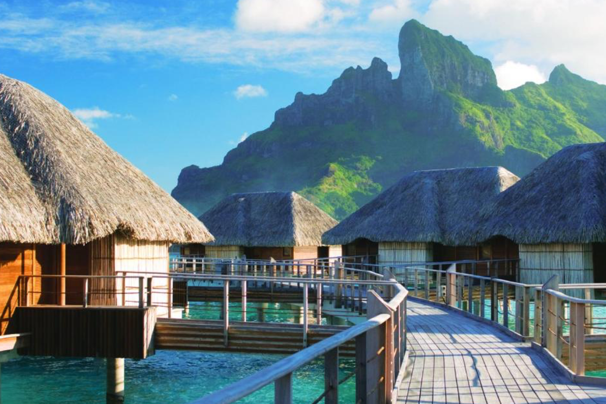Overwater bungalows at Four Seasons Resort Bora Bora with dramatic volcanic peaks rising in the background, exemplifying why it ranks among the best beach resorts in the South Pacific in 2025.