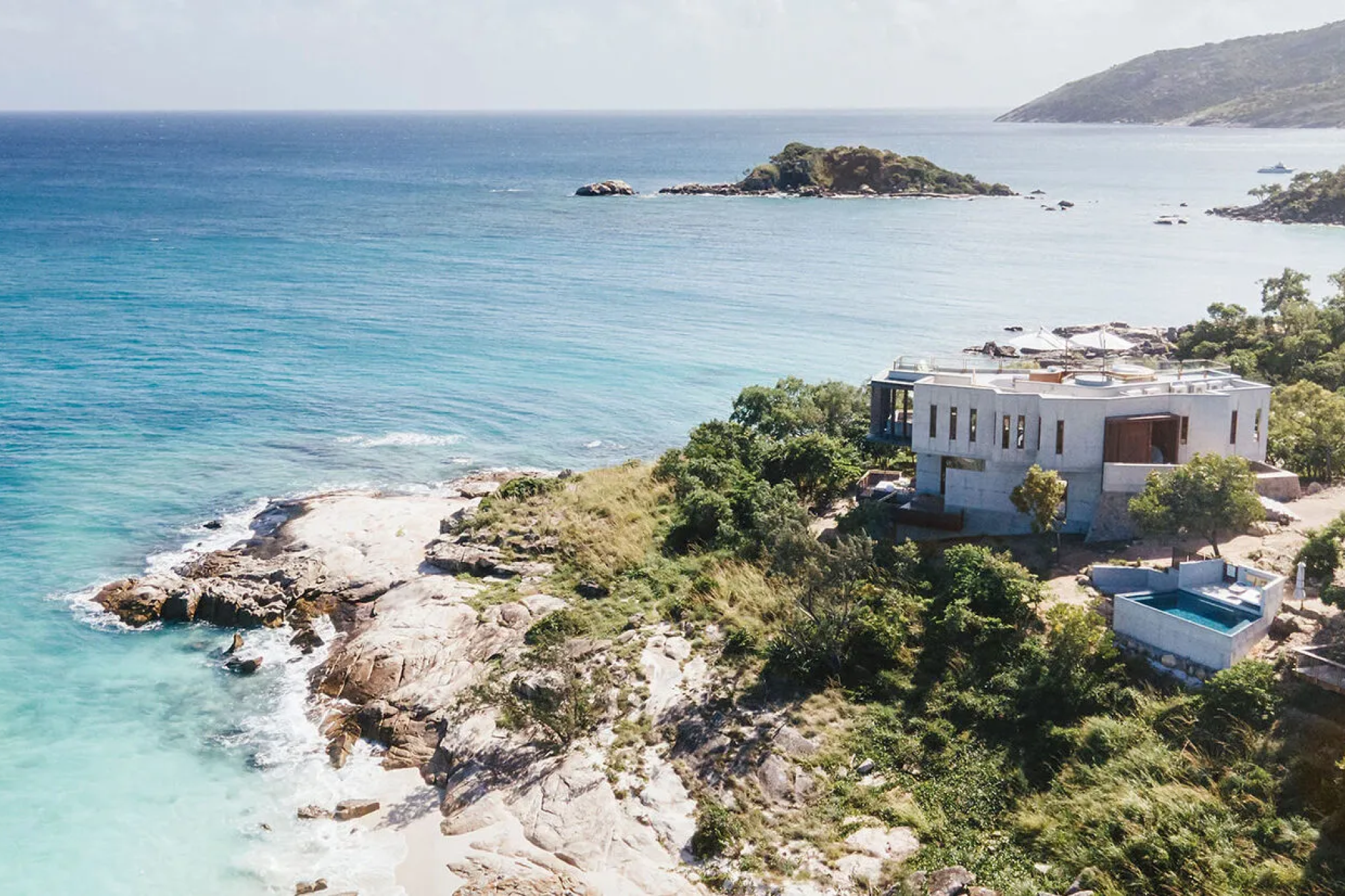 A cliffside villa at Lizard Island Resort overlooking vivid blue ocean and rocky coastline, highlighting its remote luxury setting as one of the best beach resorts in the South Pacific in 2025.