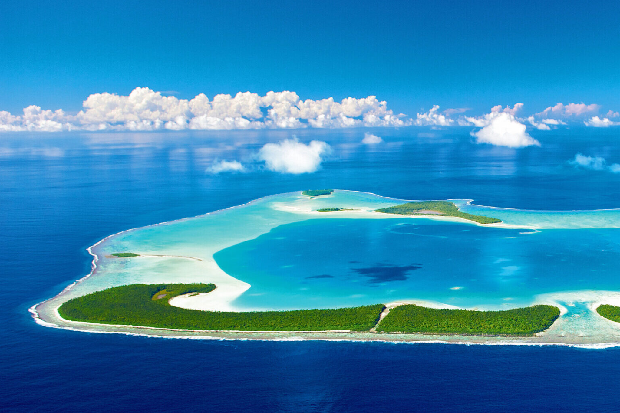 Aerial view of The Brando’s private atoll featuring untouched white-sand beaches, shallow turquoise lagoons, and dense green islets, solidifying its position as the top choice among the best beach resorts in the South Pacific in 2025.