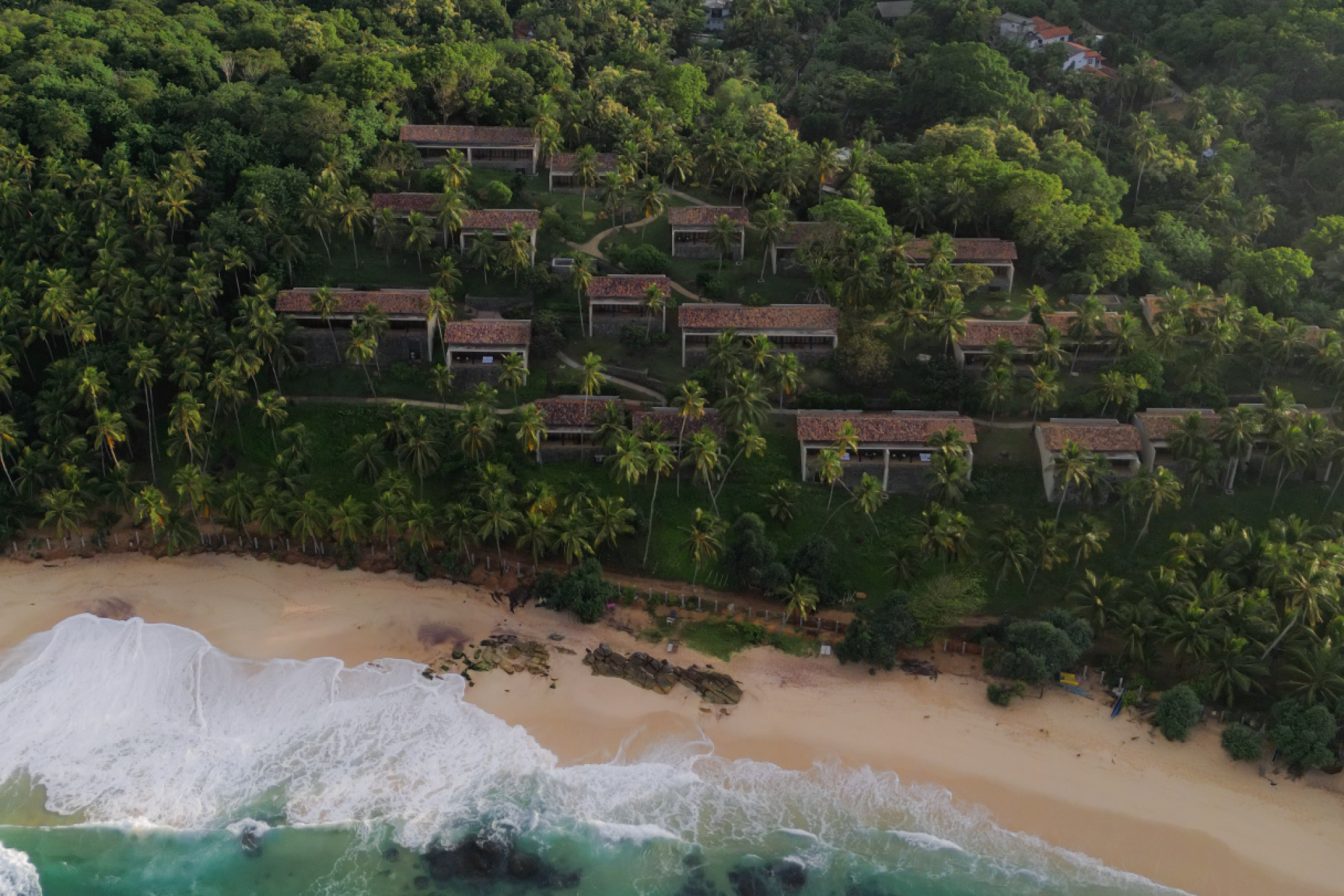 Aerial view of Amanwella’s beachfront villas surrounded by dense coconut groves along a golden-sand shoreline in Sri Lanka, illustrating why Amanwella is ranked among the best beach resorts in the Indian Ocean in 2025.