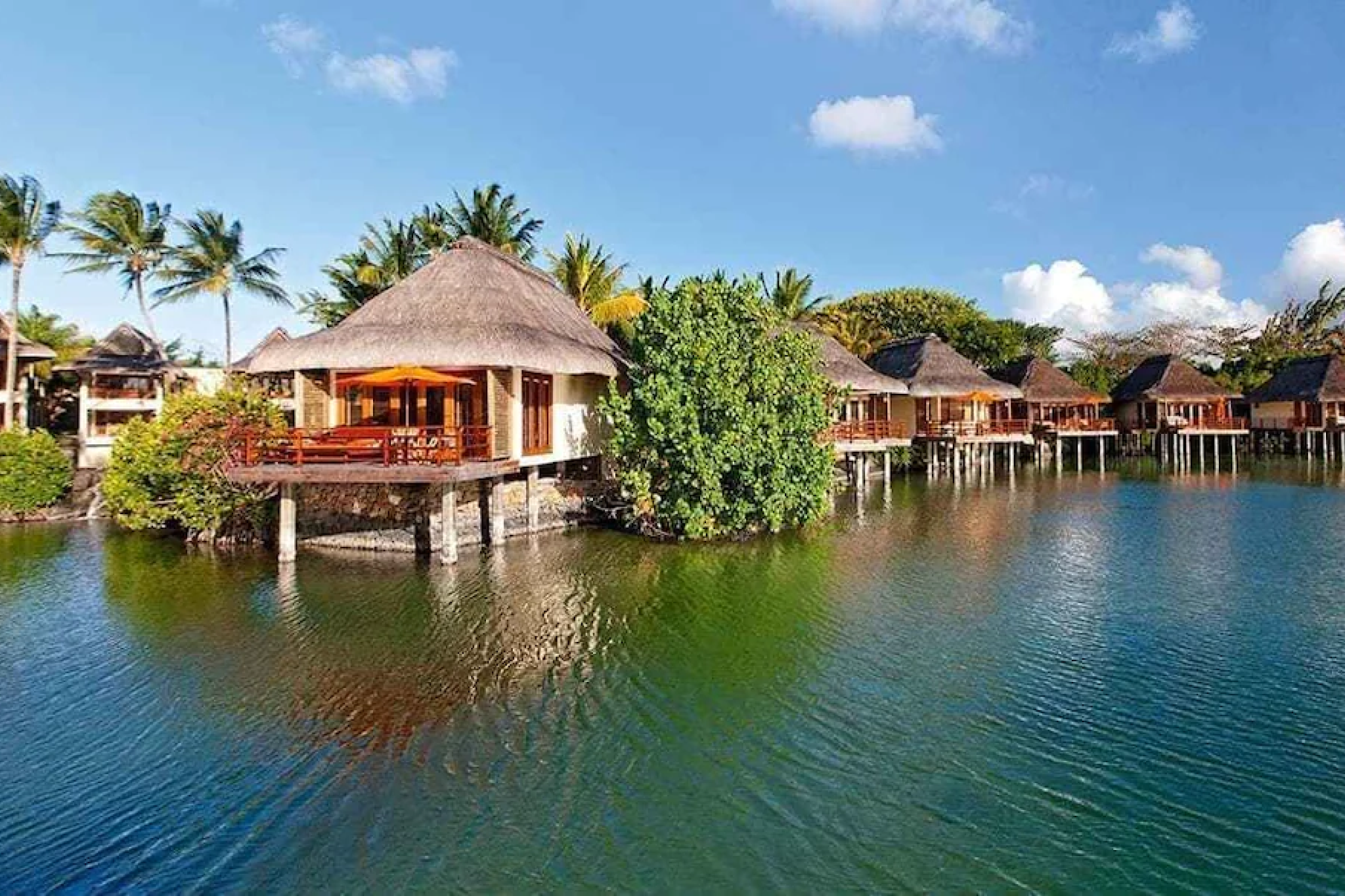 Cliffside wooden decks and palm-fringed terraces overlooking powerful ocean waves at Four Seasons Resort Seychelles, capturing the dramatic natural setting that earns it a spot among the best beach resorts in the Indian Ocean in 2025.
