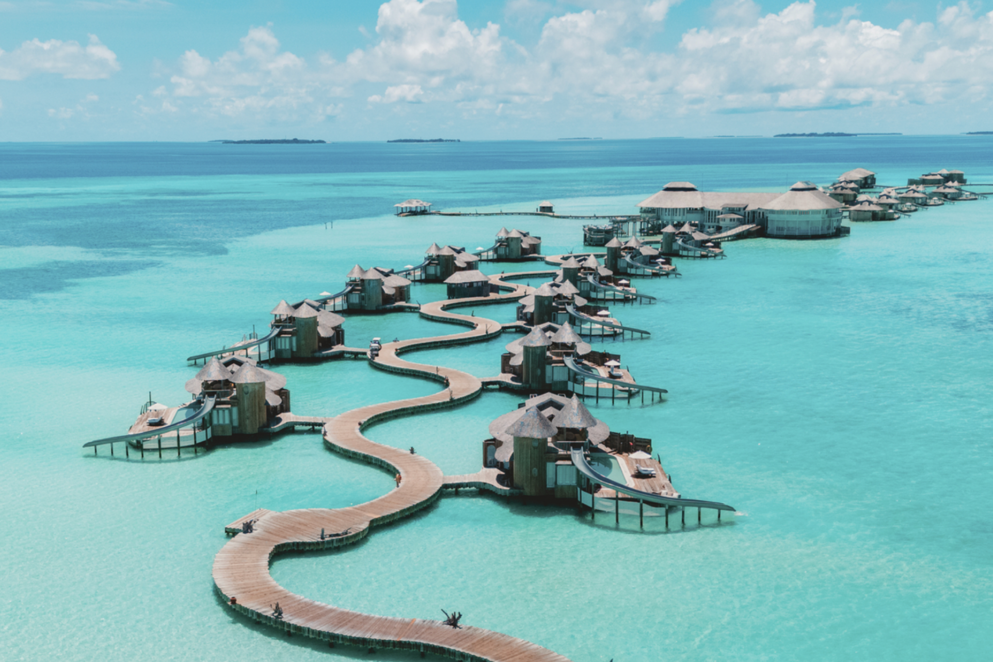 Aerial image of Soneva Jani’s iconic overwater villas connected by winding wooden boardwalks above luminous turquoise lagoon waters, perfectly representing why it ranks as the best beach resort in the Indian Ocean in 2025.