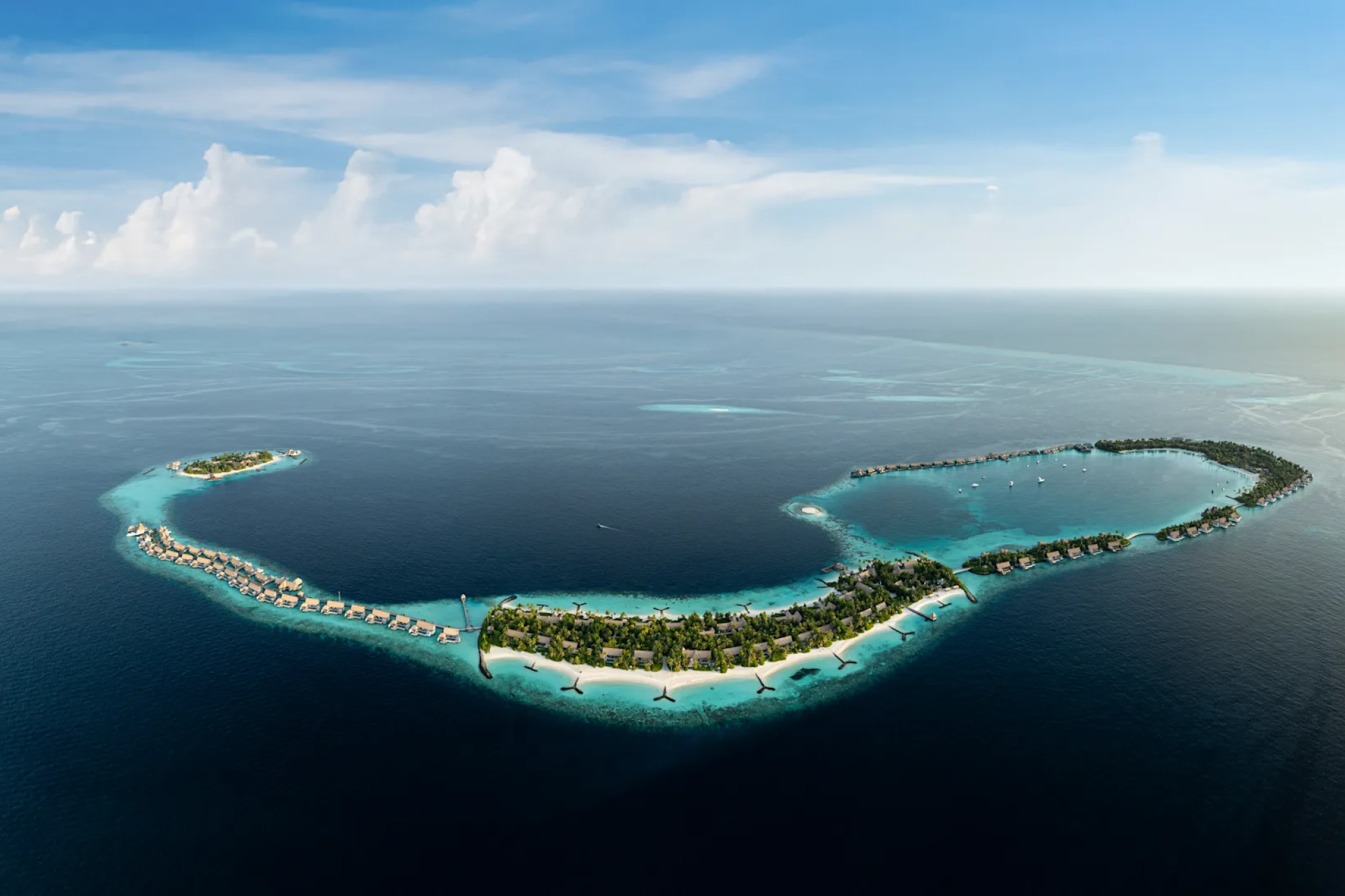 Aerial panorama of Waldorf Astoria Maldives Ithaafushi’s long chain of villas stretching across multiple islands and turquoise sandbanks, emphasizing its large-scale luxury as one of the best beach resorts in the Indian Ocean in 2025.