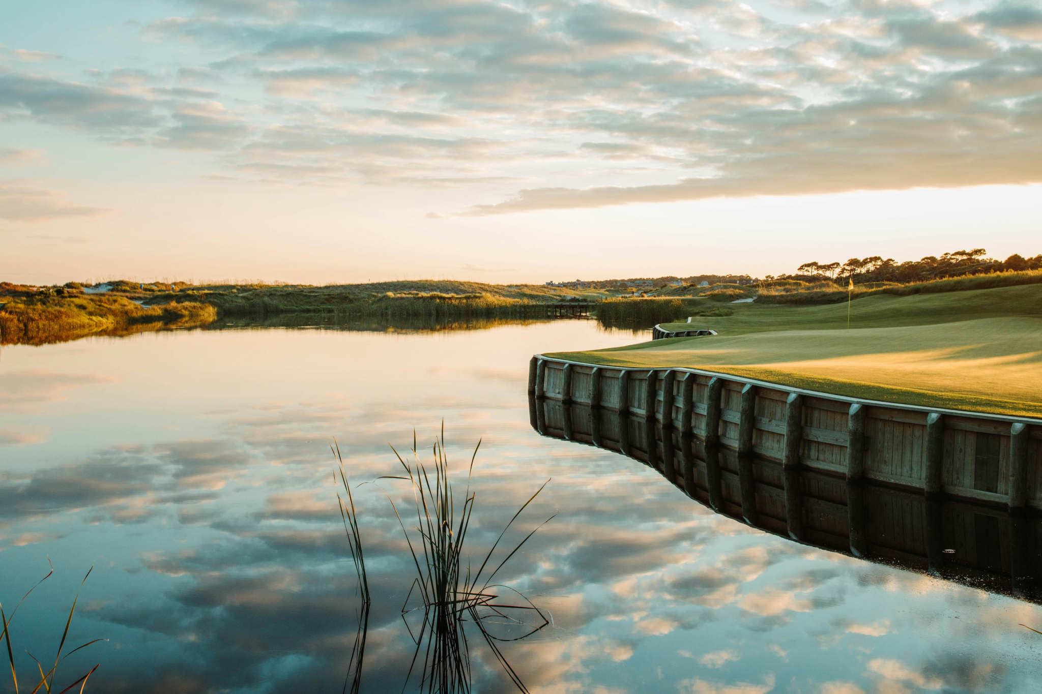 Tranquil lagoon and golf course at Kiawah Island reflecting golden sunset clouds, exemplifying the luxury resort experience at one of the best beaches on the US East Coast