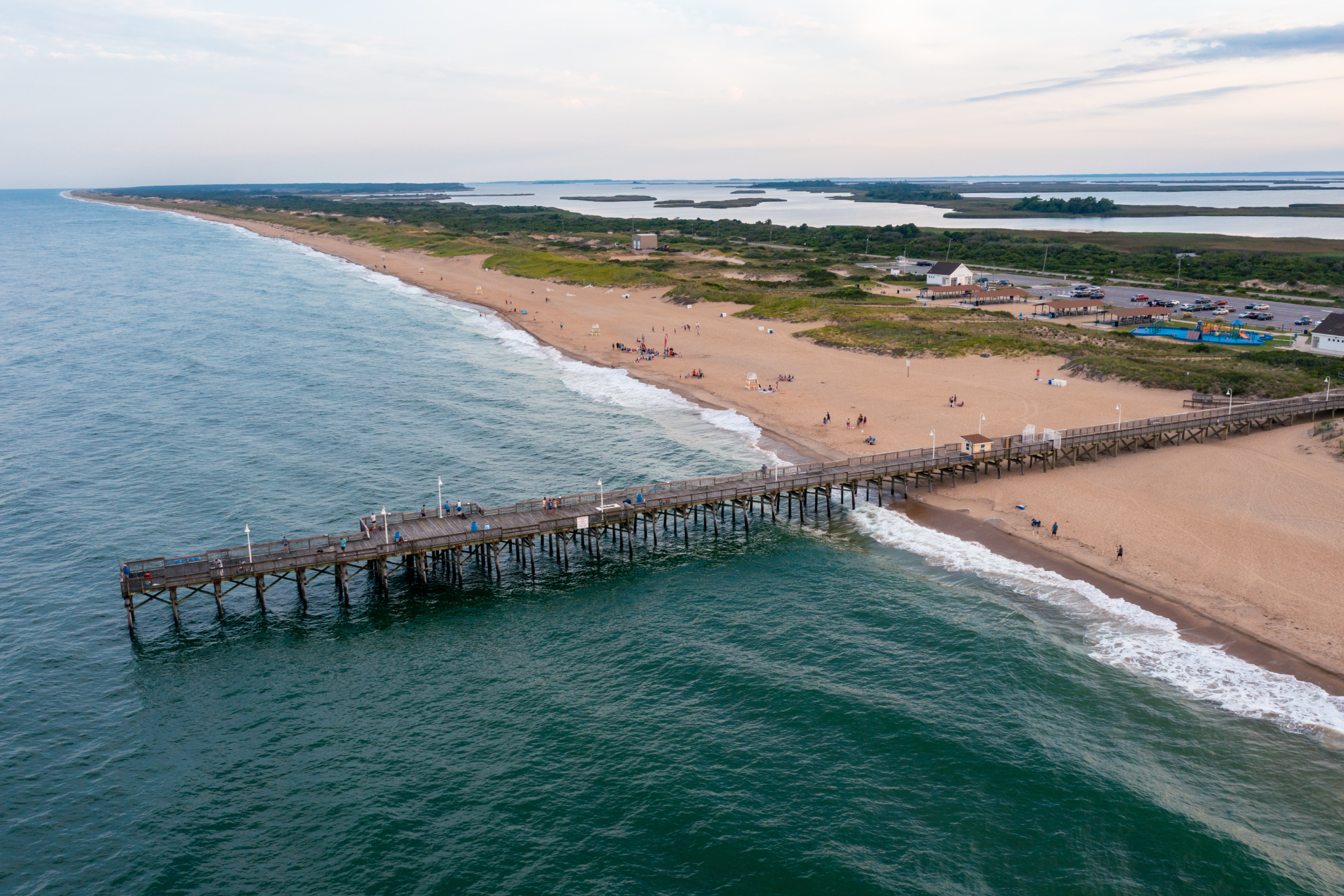 Aerial view of Sandbridge Beach Virginia featuring wooden fishing pier extending into turquoise Atlantic waters, demonstrating why it ranks among the best beaches on the US East Coast