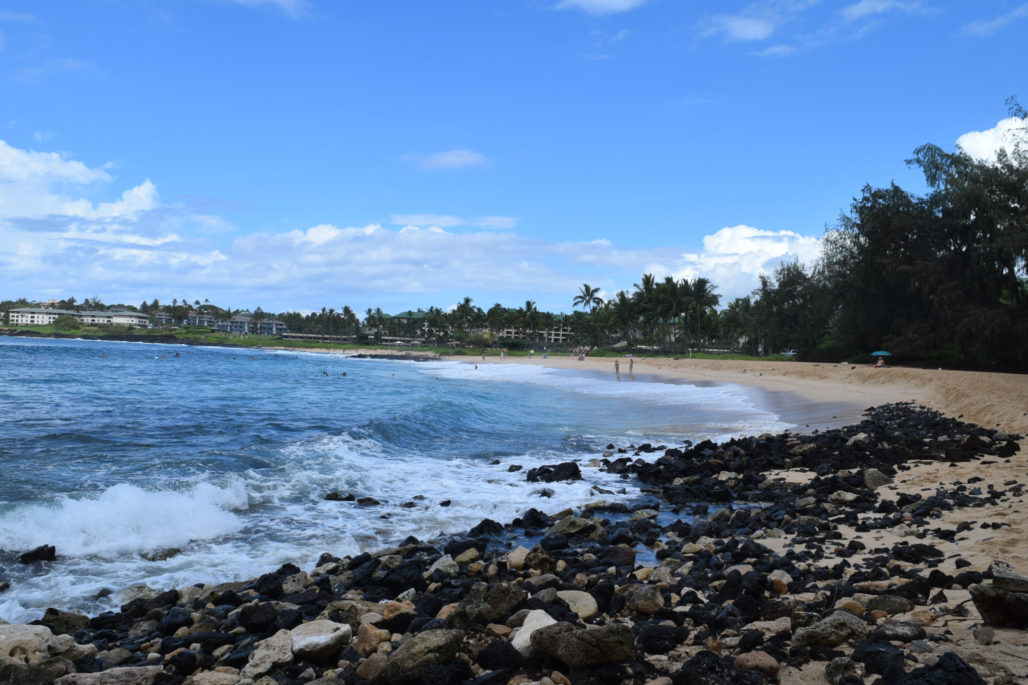 A view of Poipu’s rugged shoreline and blue waves rolling in—one of the best beaches in Kauai for snorkeling, sunbathing, and wildlife spotting.