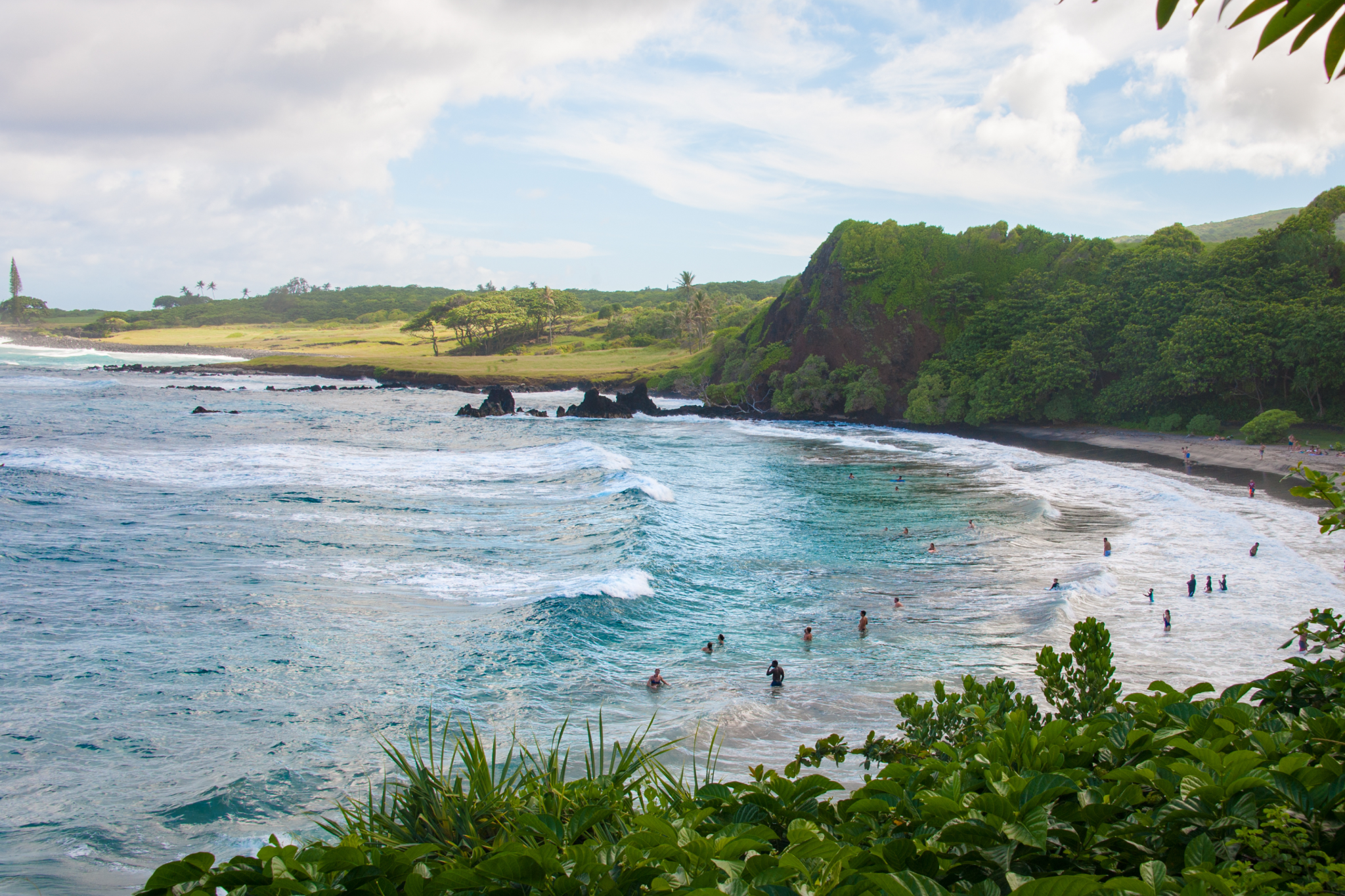 Lush greenery framing the crescent of soft sand and turquoise water at Hamoa Beach, widely regarded as one of the best beaches in Maui for natural beauty and seclusion.