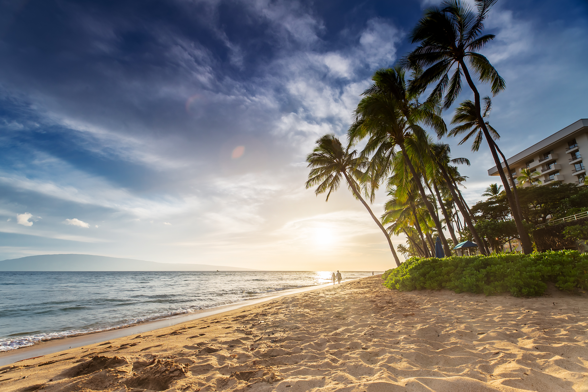 Golden sands and swaying palm trees along Kaʻanapali Beach at sunset, one of the best beaches in Maui, known for its serene ocean views and luxury resorts.