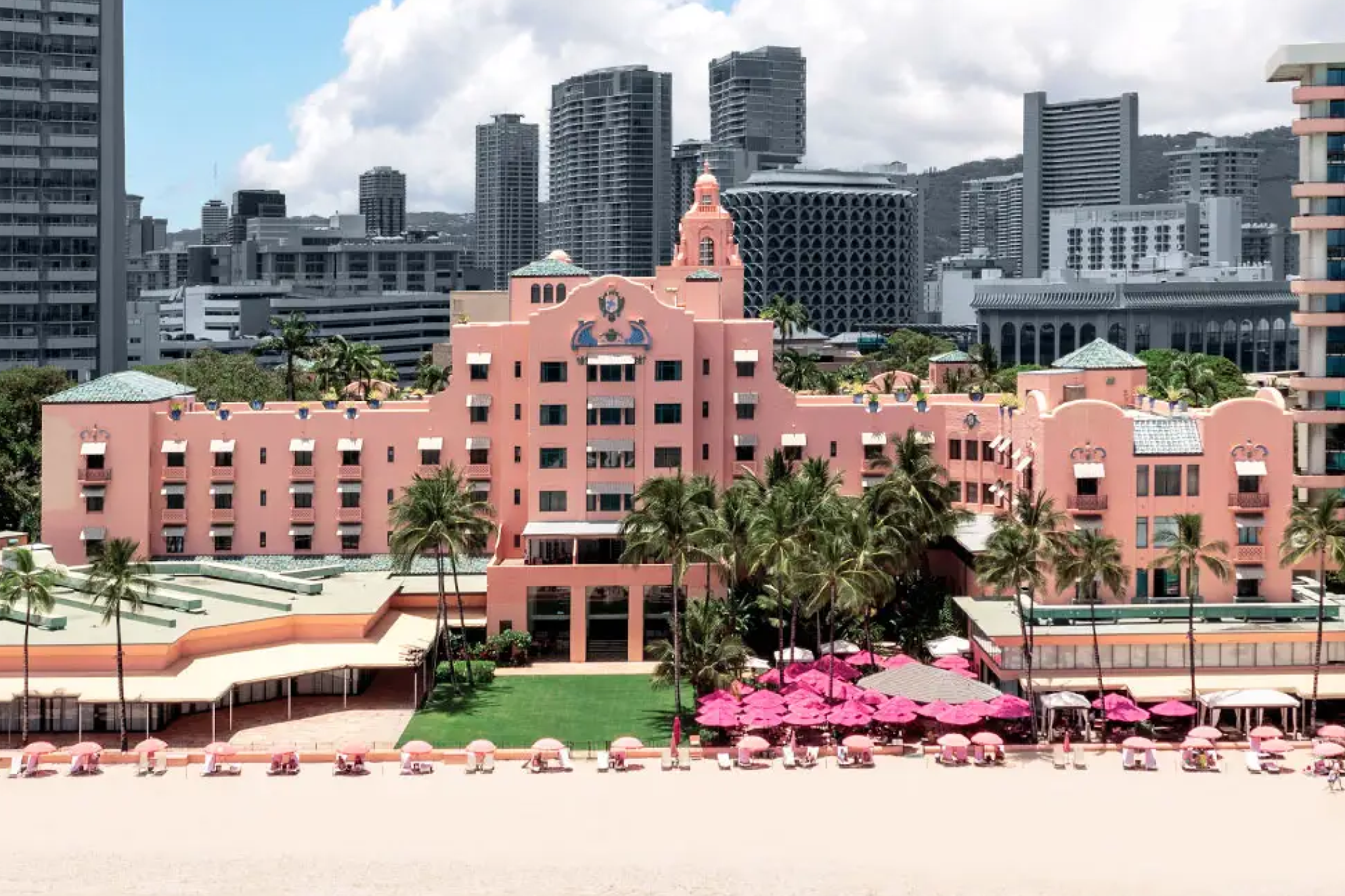 Royal Hawaiian pink palace hotel with signature coral architecture and beach umbrellas, iconic among best beachfront hotels in Waikiki