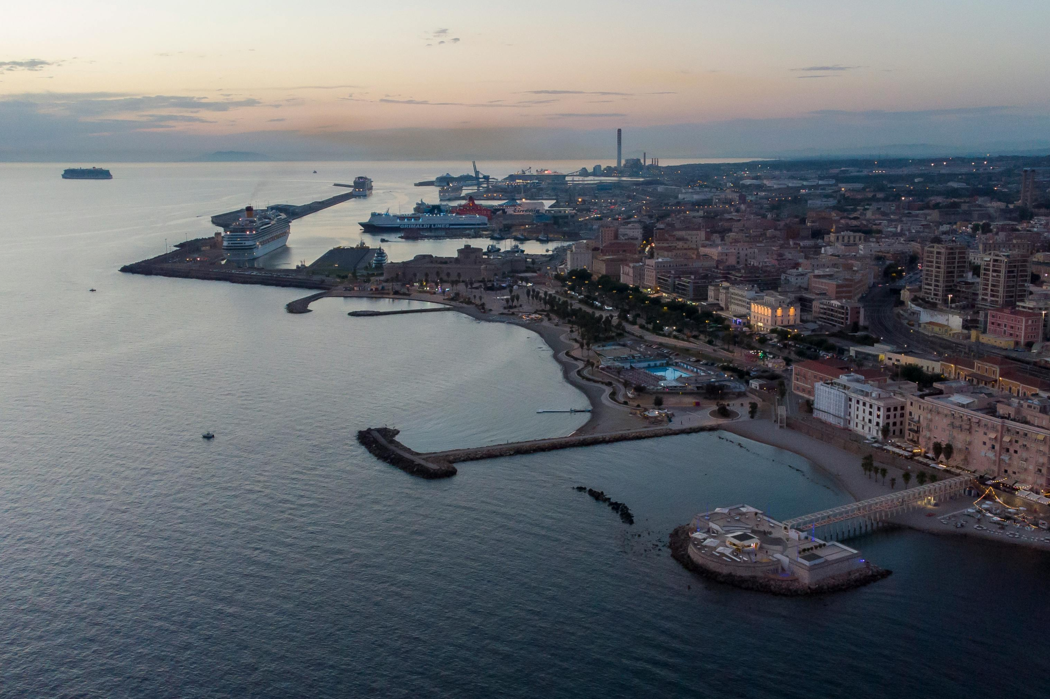 Aerial view of Civitavecchia port with cruise ships docked along the coastline at sunset, showcasing efficient facilities and access to historic Rome, representing one of the best cruise ports in 2025.