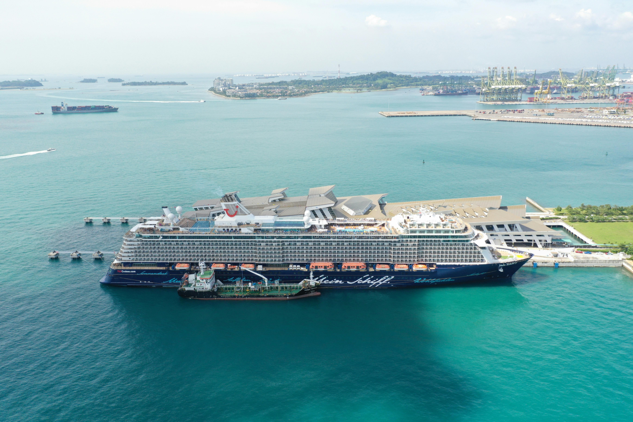Aerial perspective of a large cruise ship at Singapore’s port, highlighting modern infrastructure, smooth logistics, and proximity to cultural attractions, one of the best cruise ports in 2025.