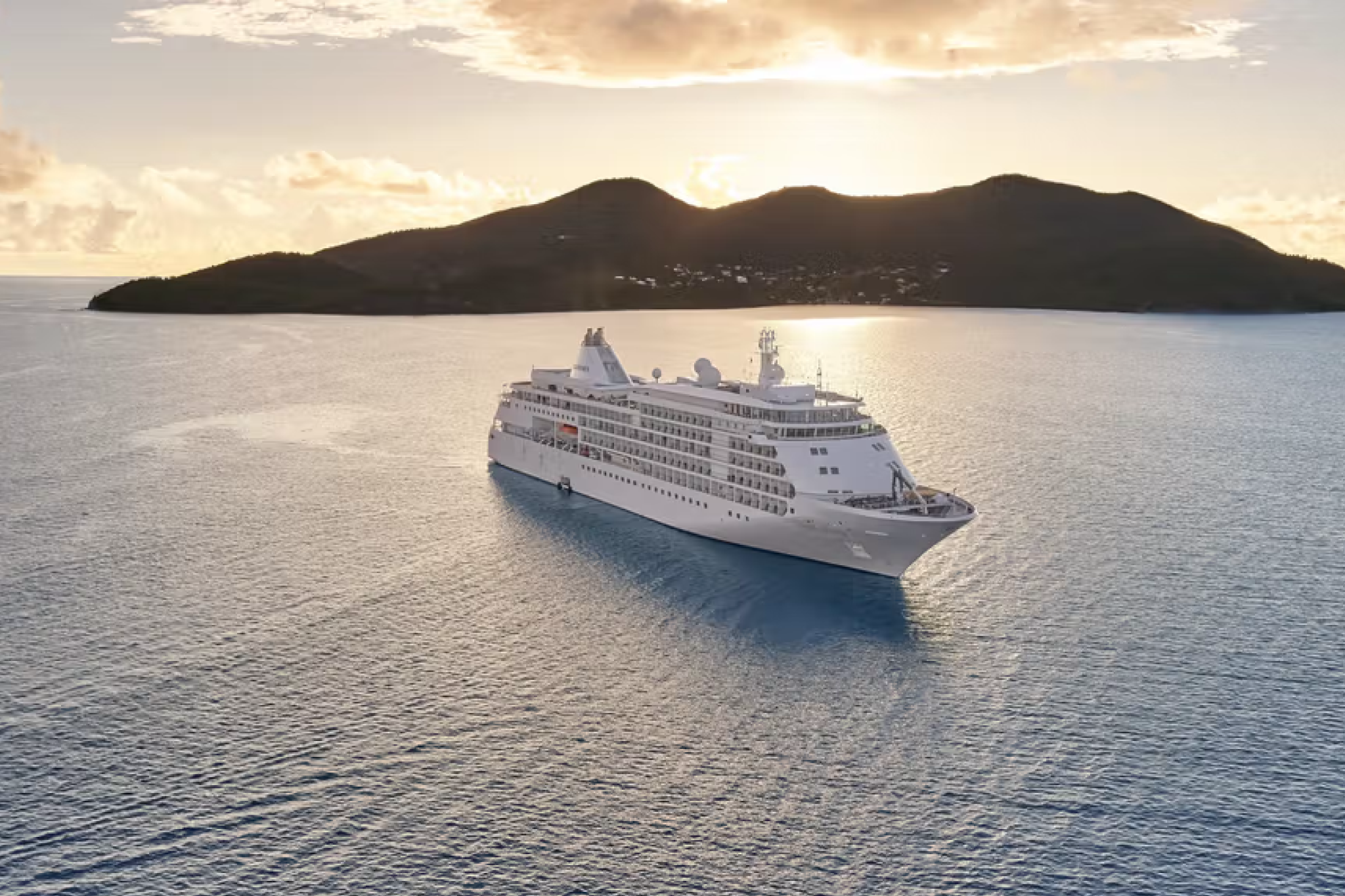 Silversea luxury ship anchored in tropical waters at sunset — a refined and exotic pick among the best cruises for Christmas.