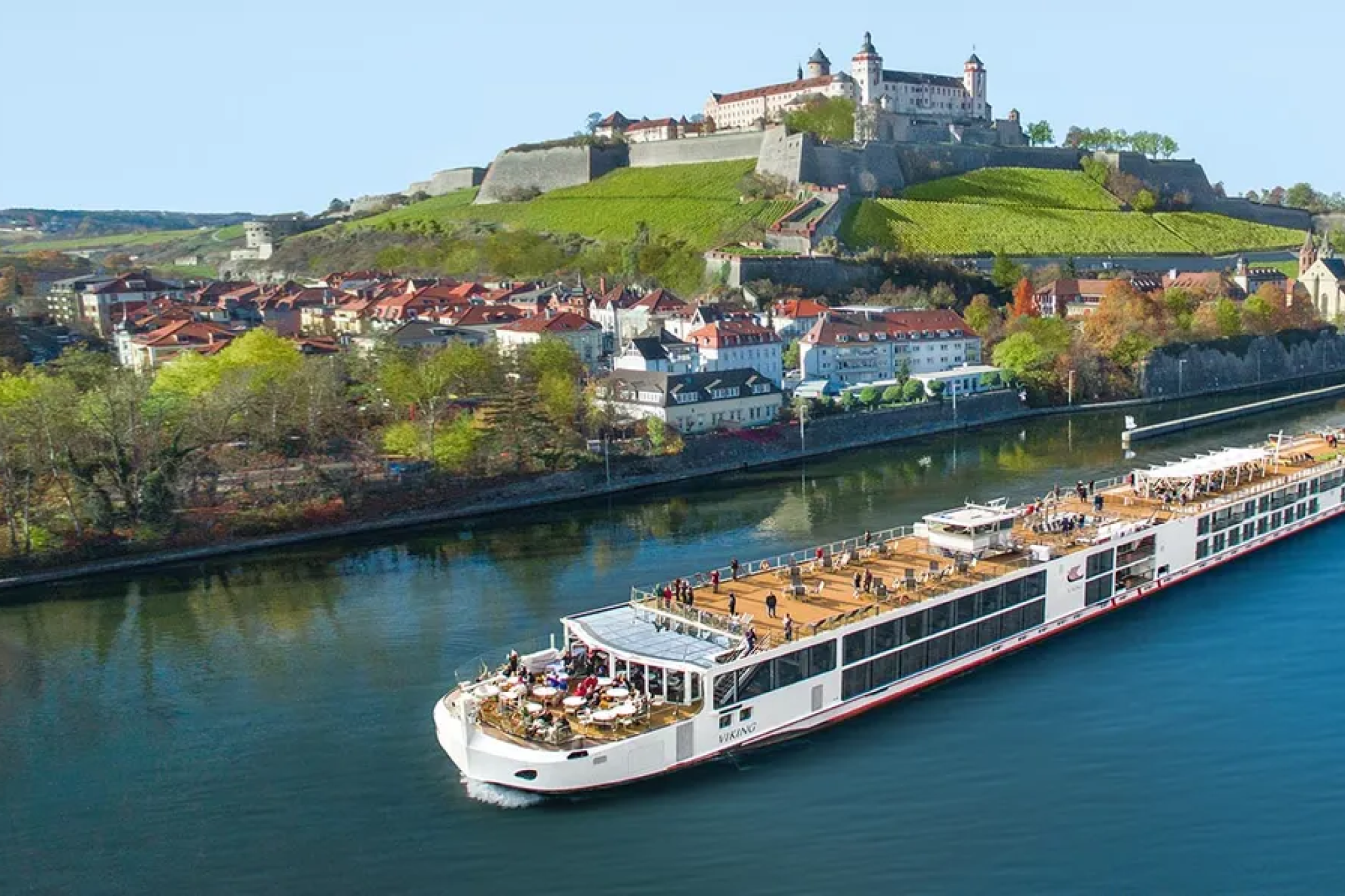 Viking longship sailing past European castles and villages — one of the best cruises for Christmas featuring Rhine holiday markets.