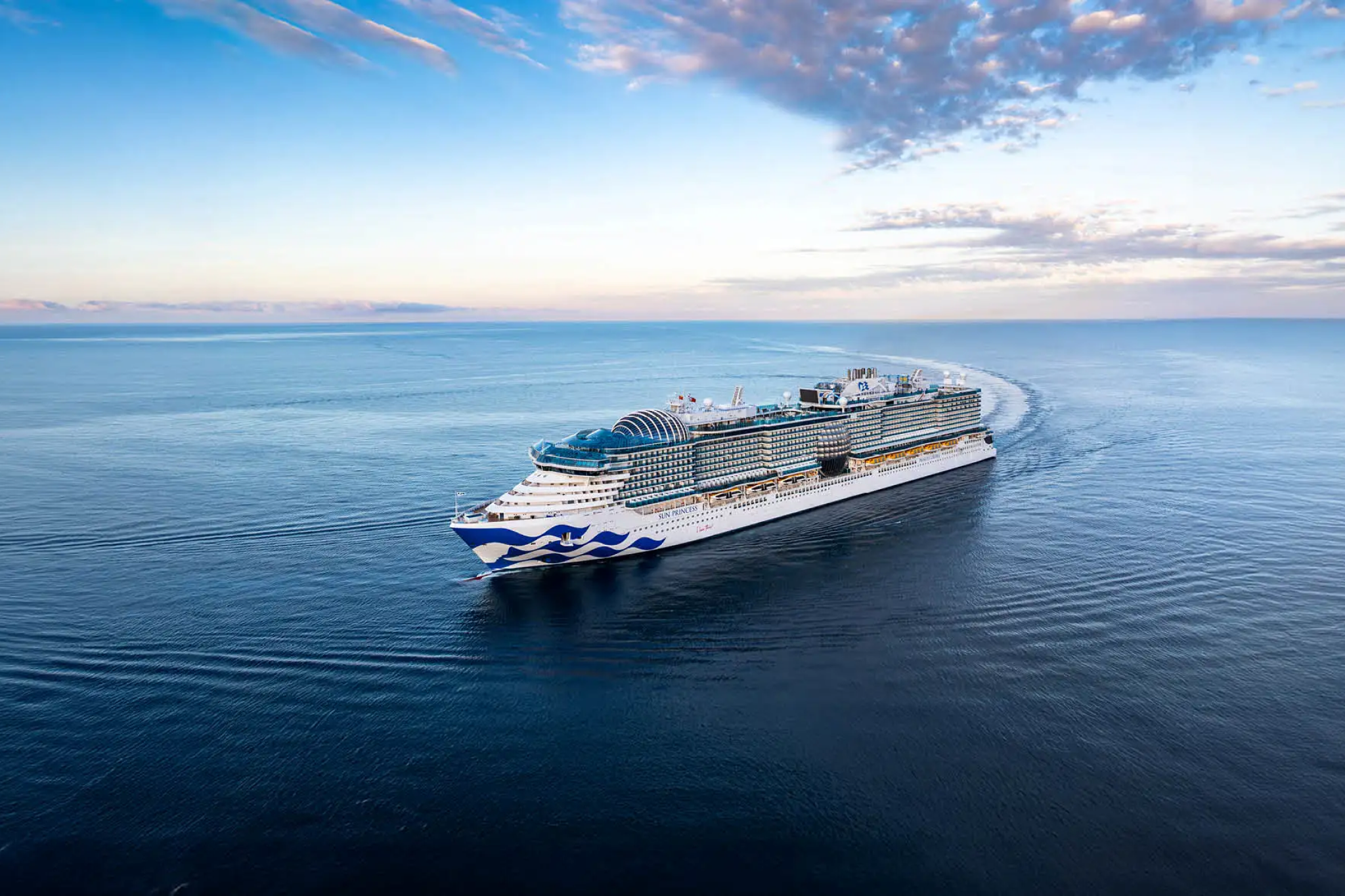 Princess Cruises ship gliding through calm ocean waters at sunset, known for multigenerational travel experiences and ranking among the Best Cruises for Families.