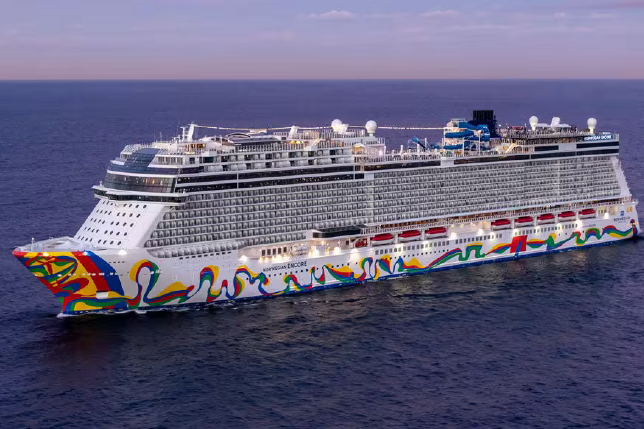 Norwegian Encore ship sailing at sunset, its colorful hull reflecting NCL’s freestyle spirit — part of the Best Cruises for Honeymoon options for couples who value flexibility and fun at sea.