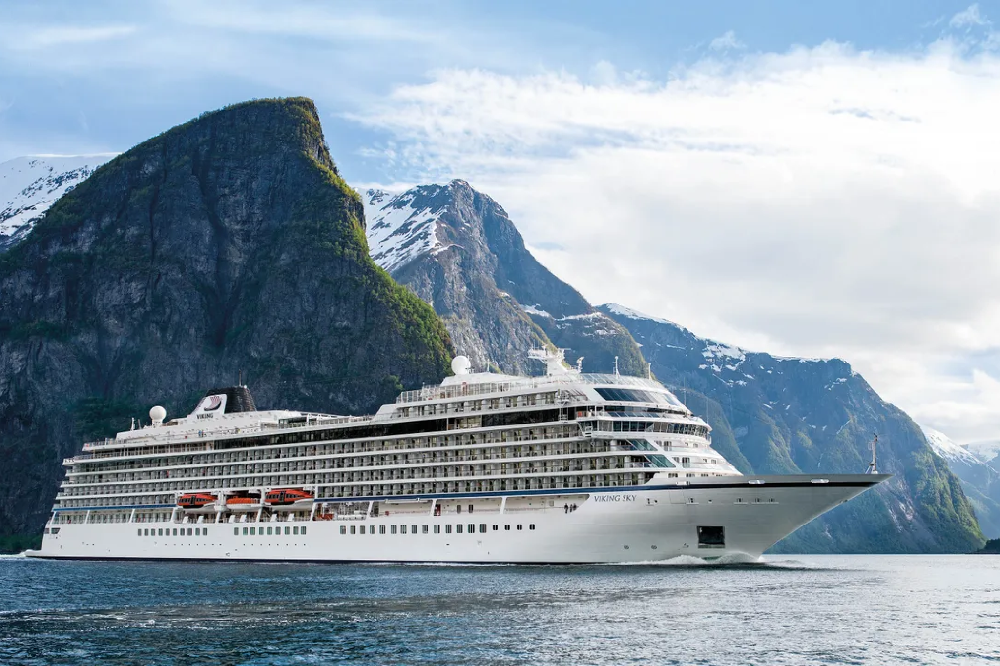 Viking Sky ship sailing through Norwegian fjords under snow-capped mountains, representing refined and scenic voyages with Viking Cruises — among the Best Cruises for Honeymoon couples seeking tranquility and culture.