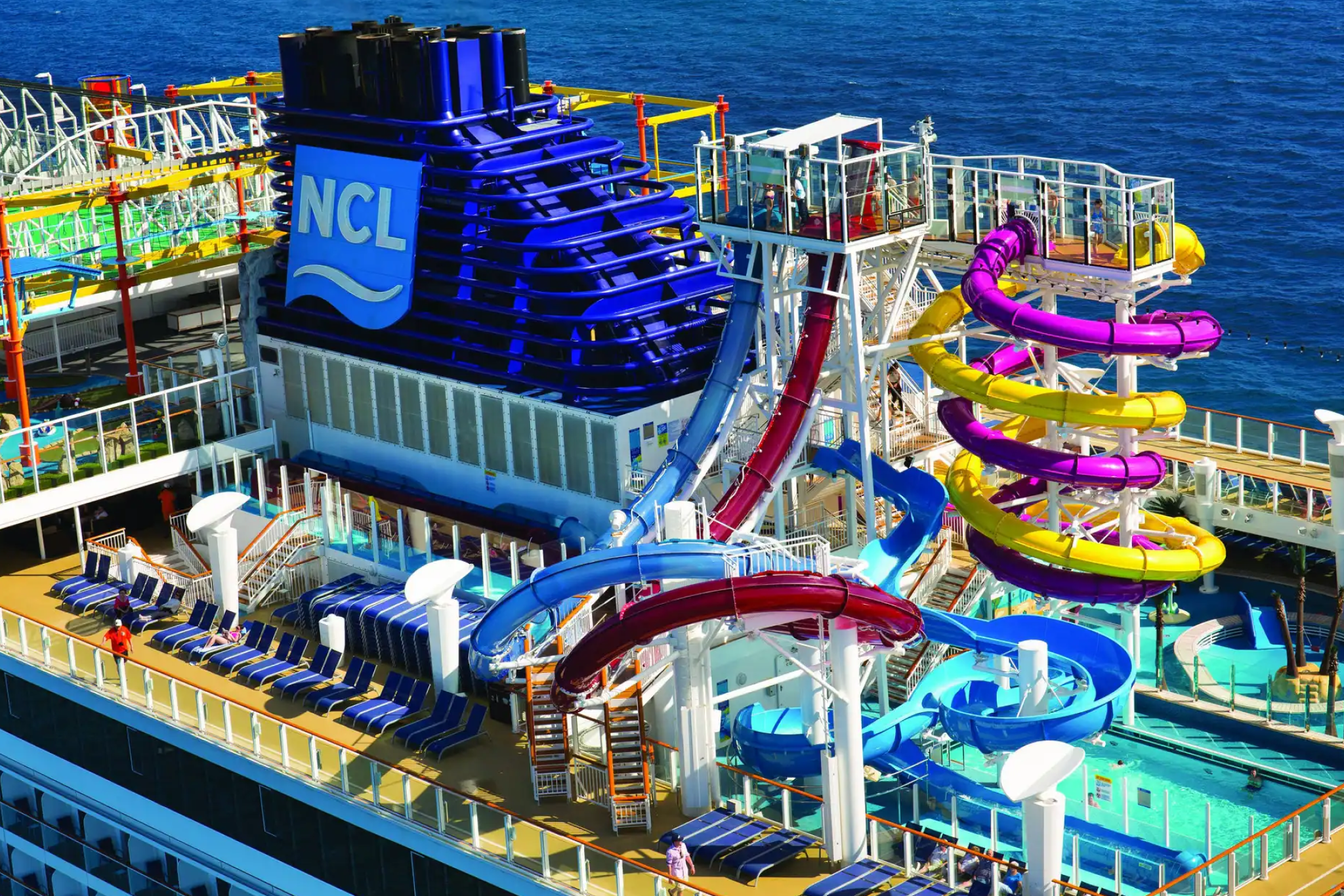 Top deck of a Norwegian Cruise Line ship with colorful waterslides — a sophisticated yet lively option on the list of best cruises for partying.