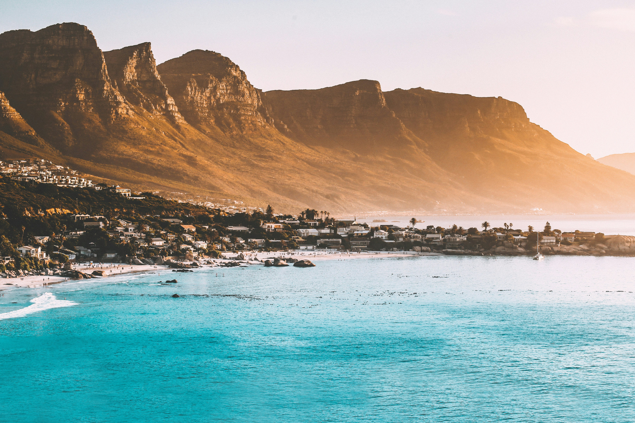 The iconic coastline of Cape Town with Table Mountain in the background and Clifton Beach below, showcasing why it ranks as one of the best destinations for Christmas on the beach in the Southern Hemisphere.