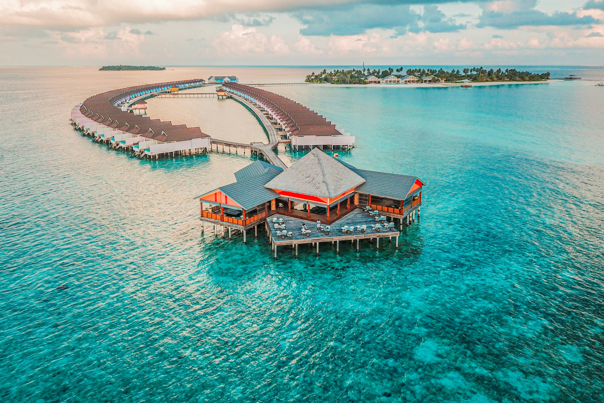 Overwater bungalows and a luxury deck surrounded by crystal-clear waters in the Maldives — a dreamy setting and one of the best destinations for Christmas on the beach for ultimate seclusion.