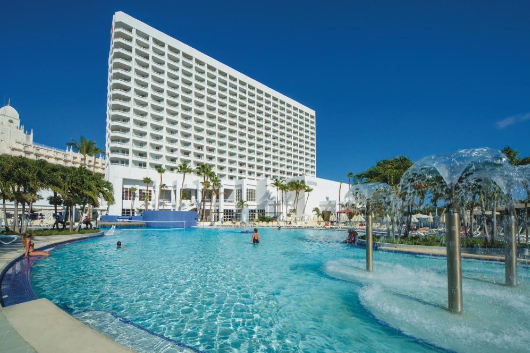 Hotel Riu Palace Antillas, adults-only luxury and one of the best resorts in Aruba, featuring a vast pool deck, fountains, and modern beachfront architecture.