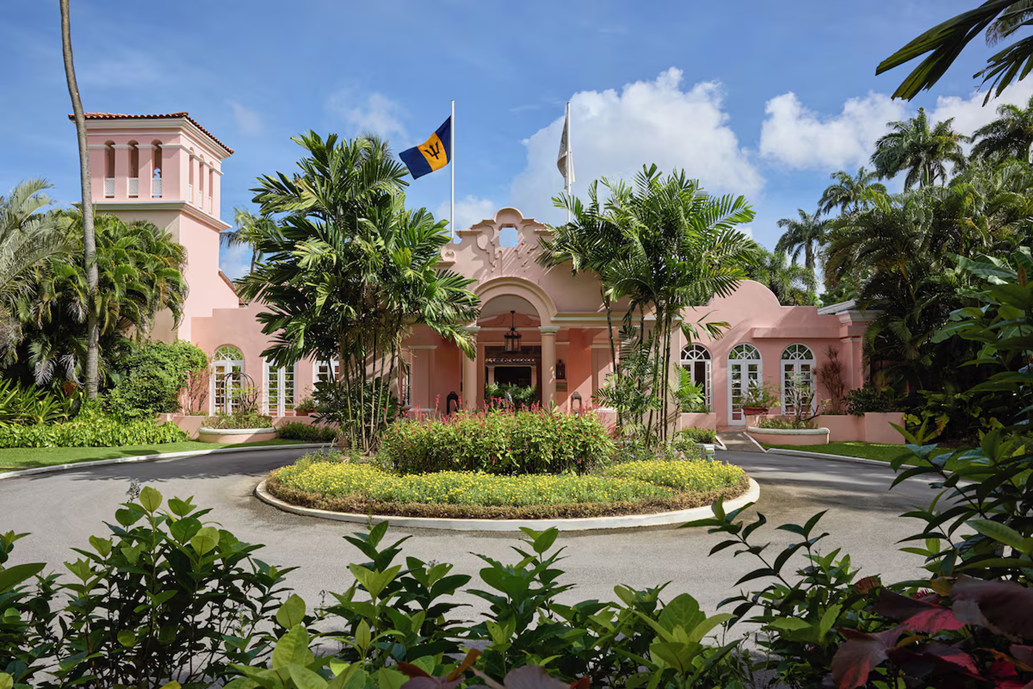 Elegant pink façade of Fairmont Royal Pavilion with tropical landscaping, a beachfront icon ranked among the best luxury resorts in Barbados.