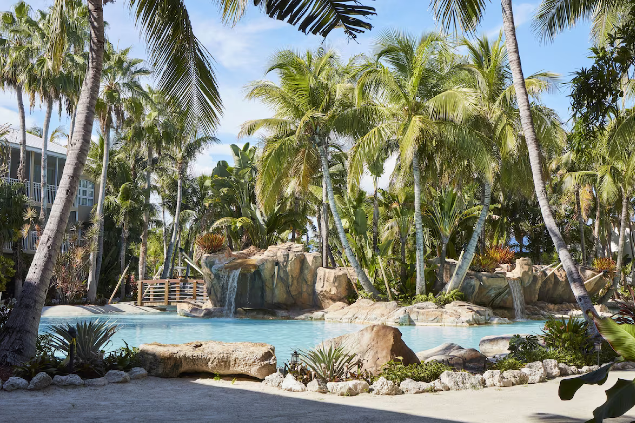 Lagoon pool with waterfall surrounded by palm trees at Cheeca Lodge & Spa, a legendary retreat and one of the best resorts in Florida Keys.
