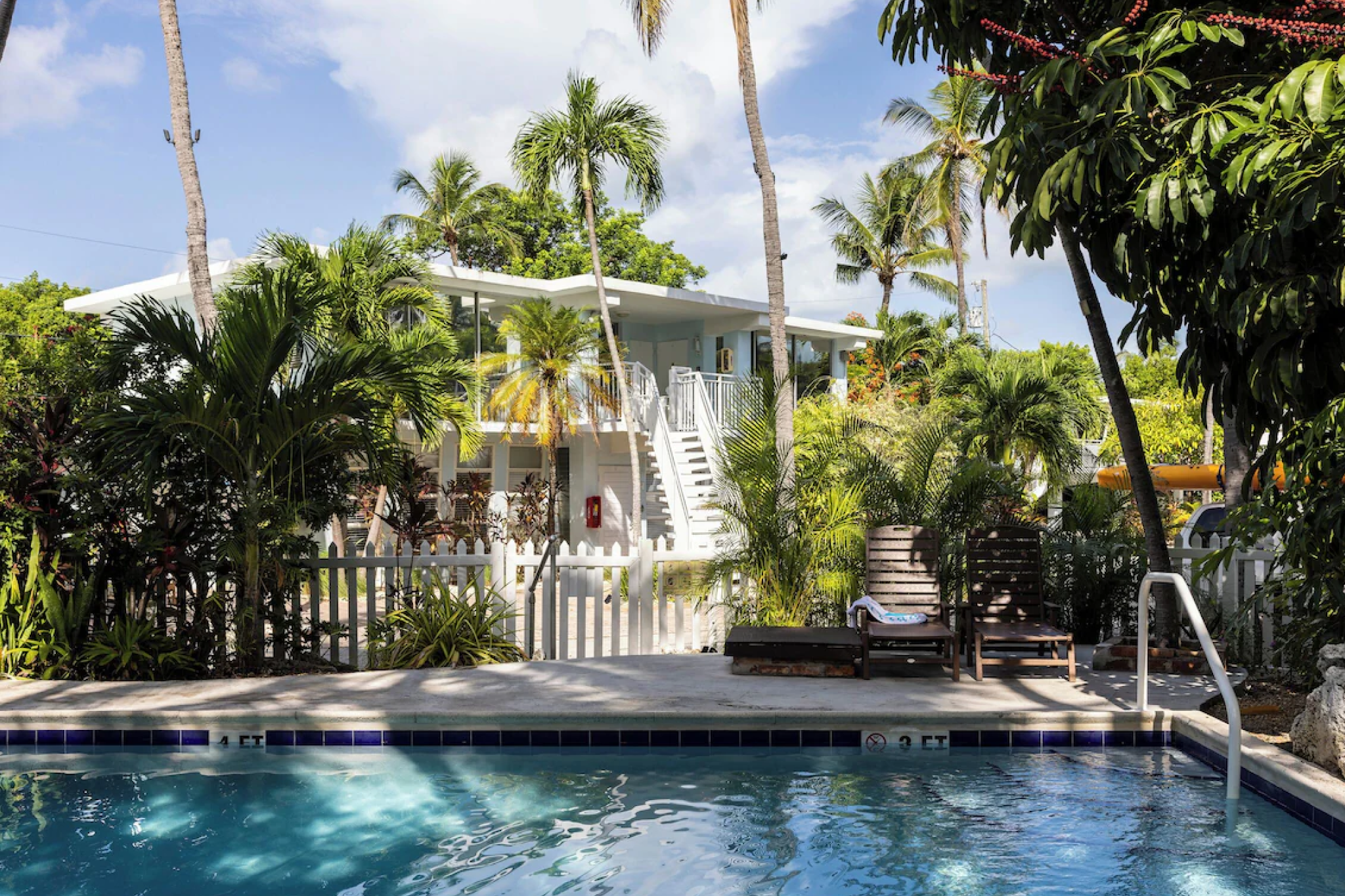 Cozy poolside setting surrounded by lush greenery at La Jolla Resort, a charming hideaway and one of the best resorts in Florida Keys.