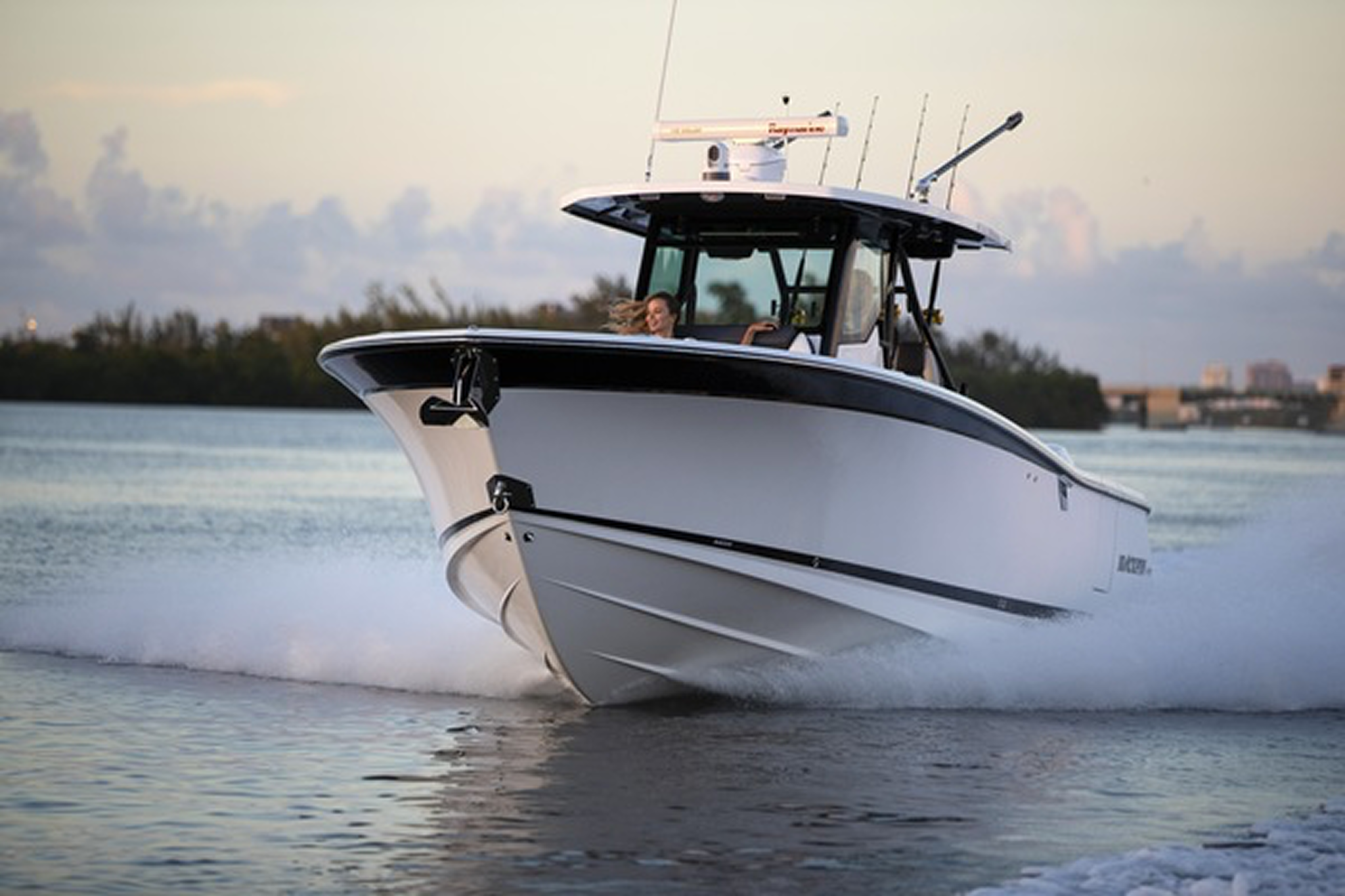 Front angle of the Blackfin 332CC on plane, highlighting bow flare and hardtop structure.