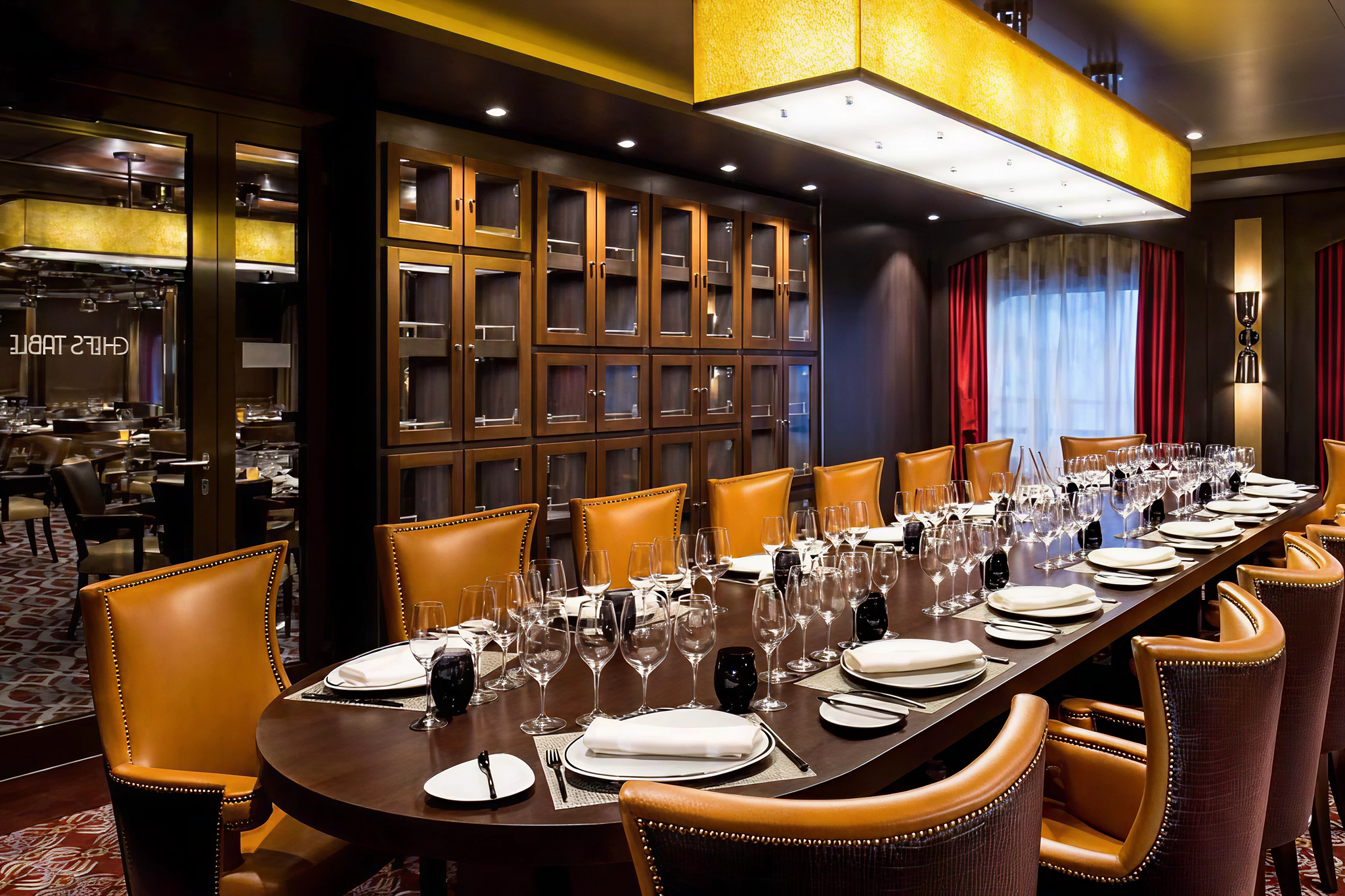 Chef’s Table dining experience aboard Brilliance of the Seas with elegant table settings, leather chairs, and wine storage.