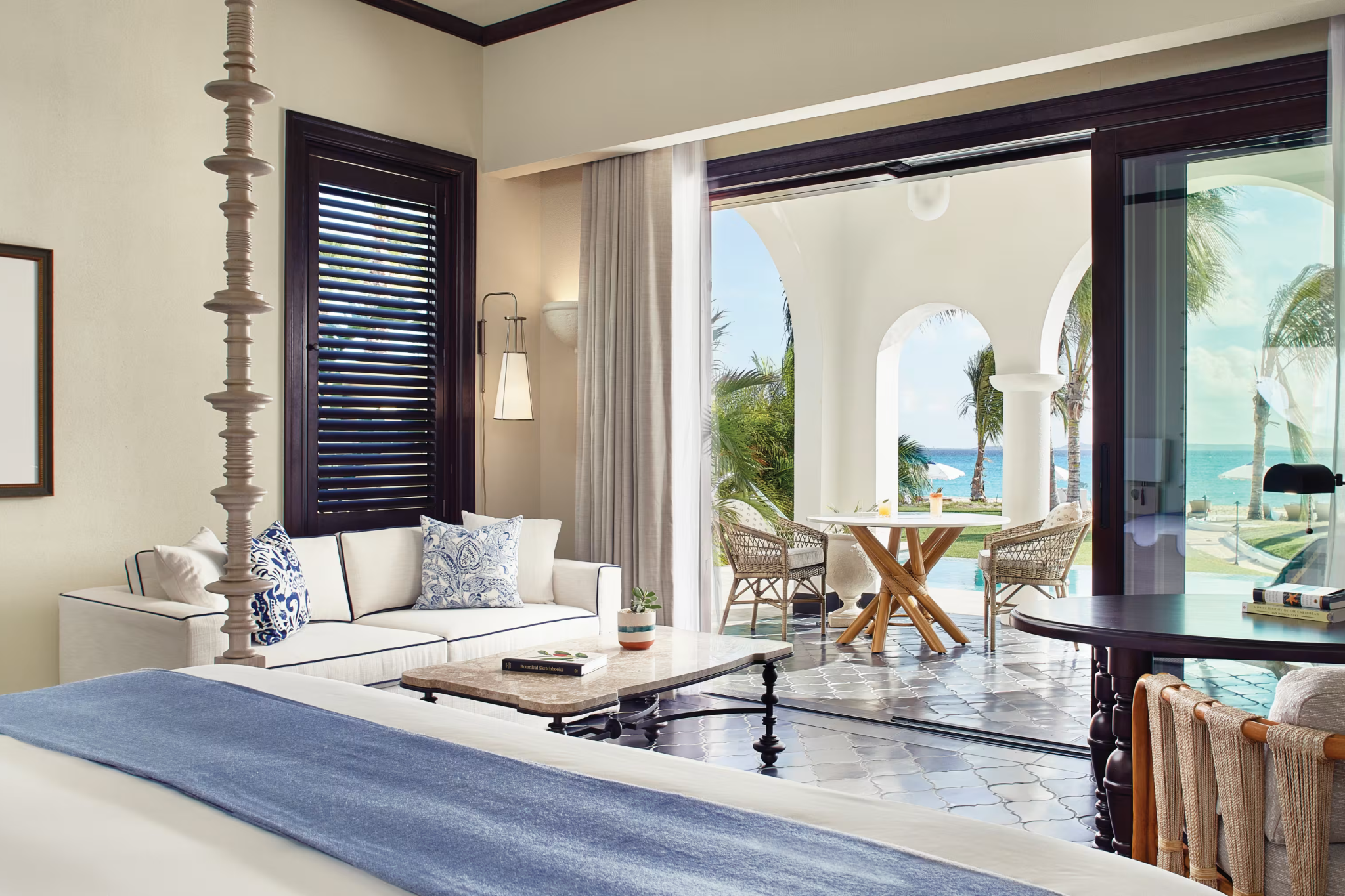 Elegant beachfront suite at Cap Juluca with ocean-facing terrace, arched patio doors, and coastal decor overlooking the Caribbean Sea.